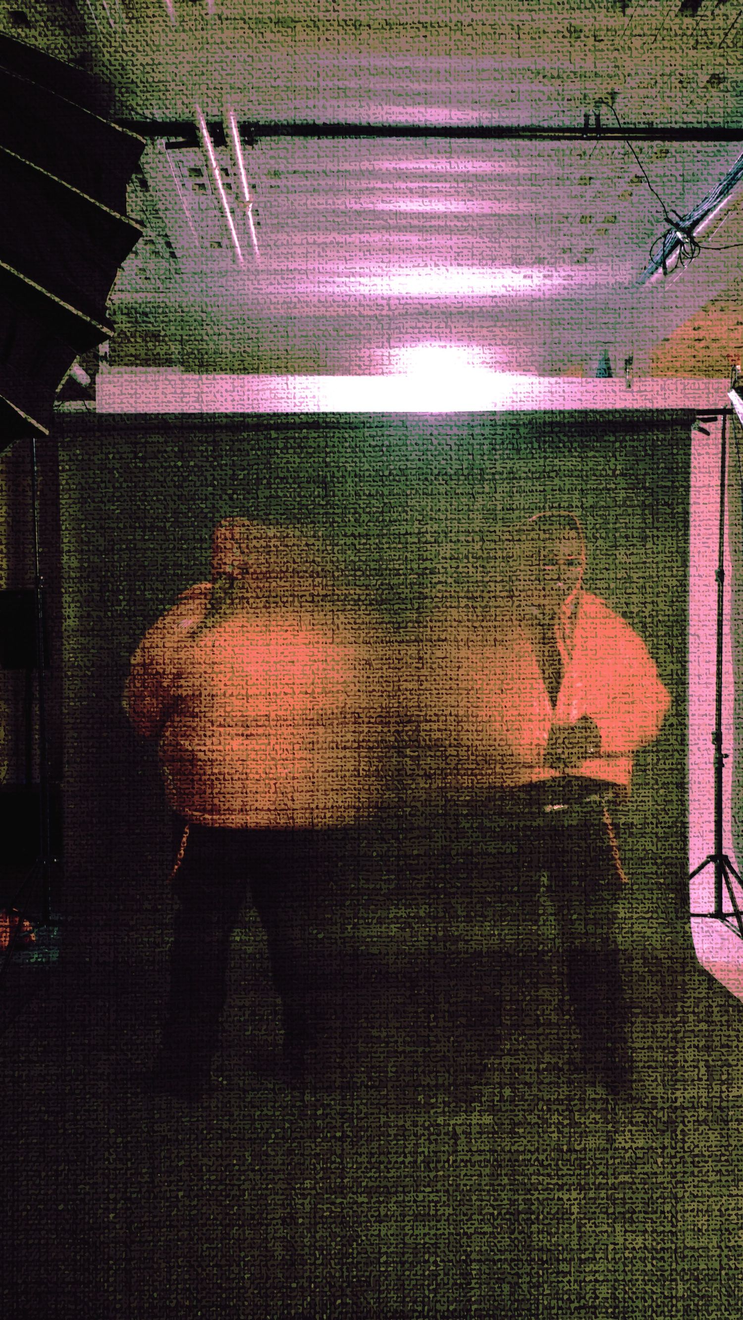 Abstract motion blur sequence showing dark silhouettes against pink lighting in an indoor space.