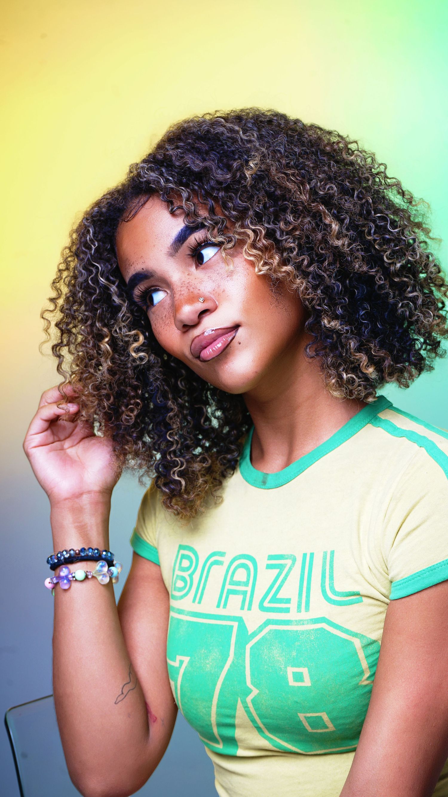 A series of photos showing natural curly hair and a mint green Brazil t-shirt against a gradient background.