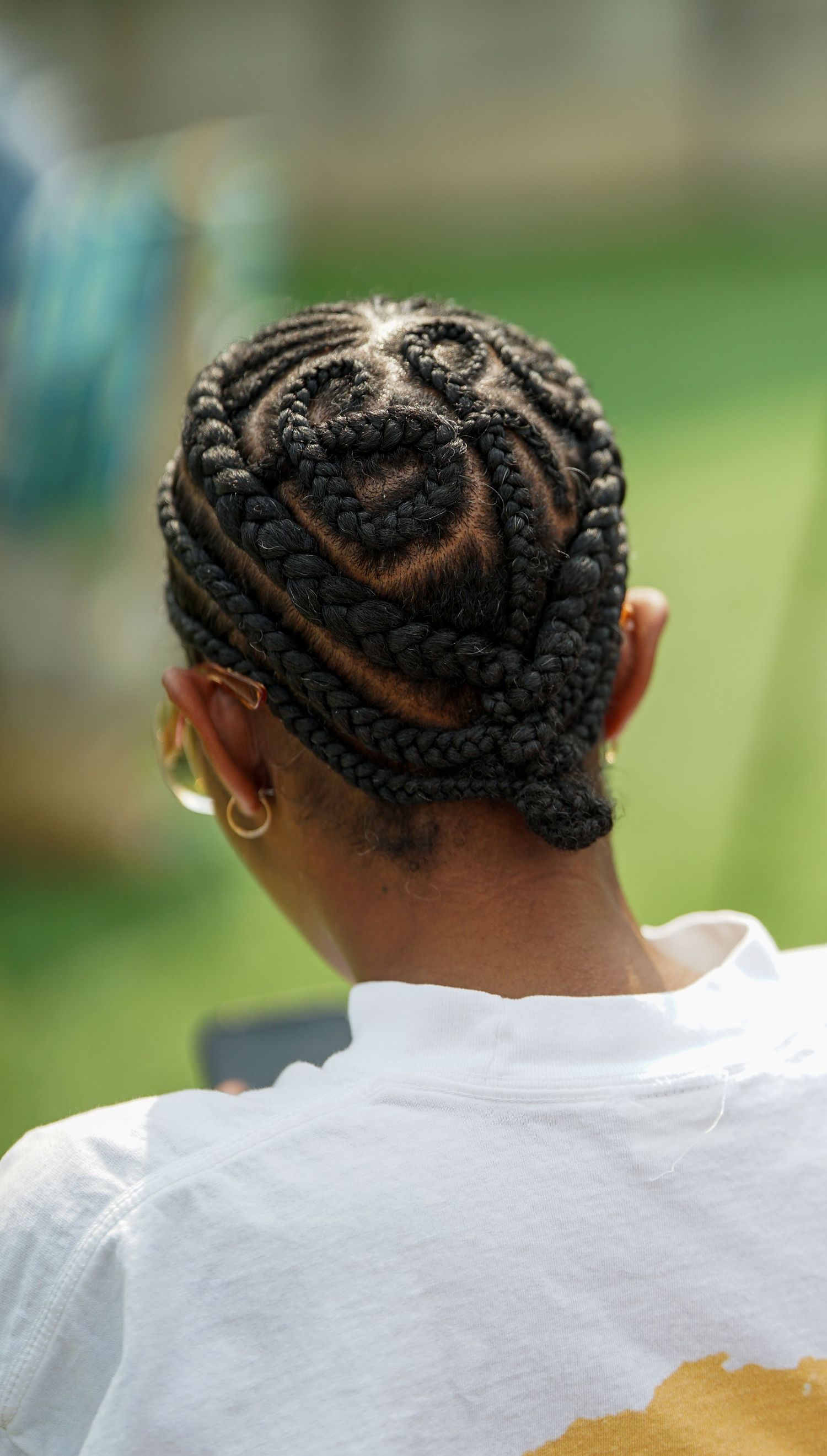 Close-up view of intricate cornrow braided hairstyle from behind.