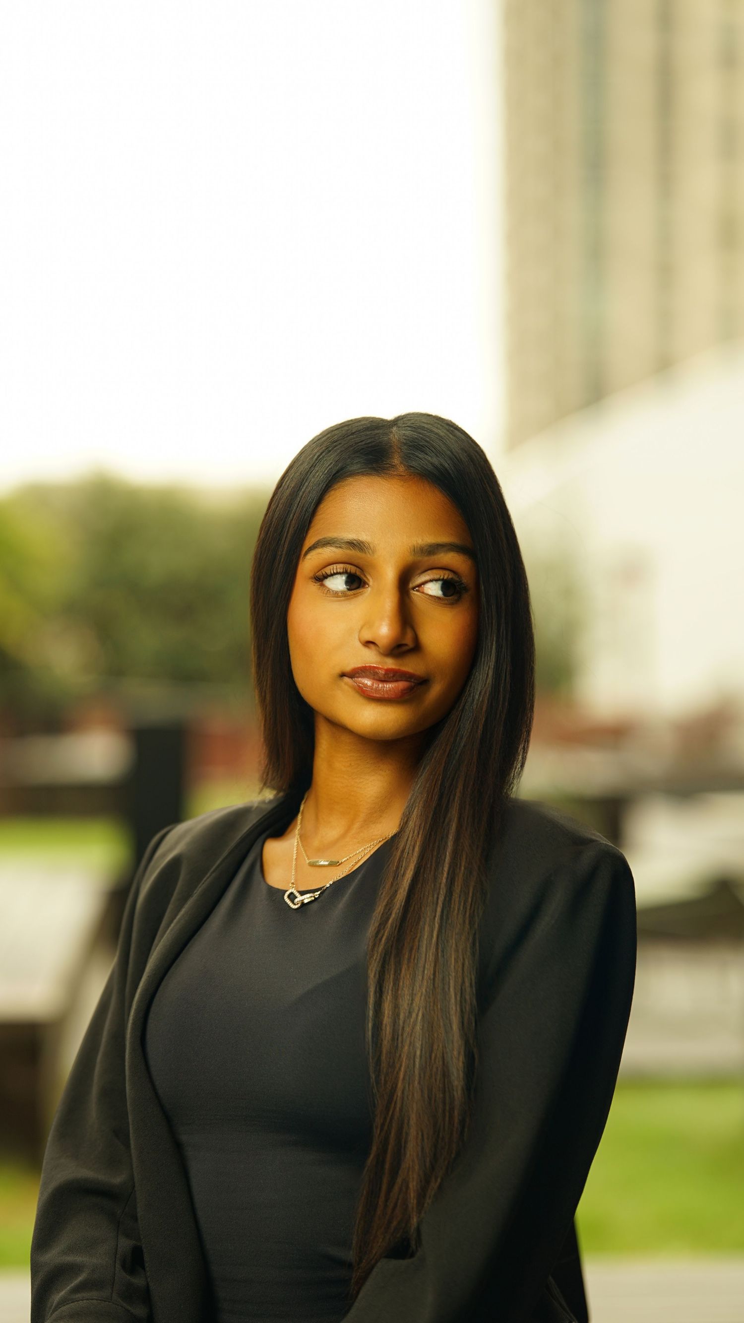 Professional in black attire poses for portrait with long straight hair.