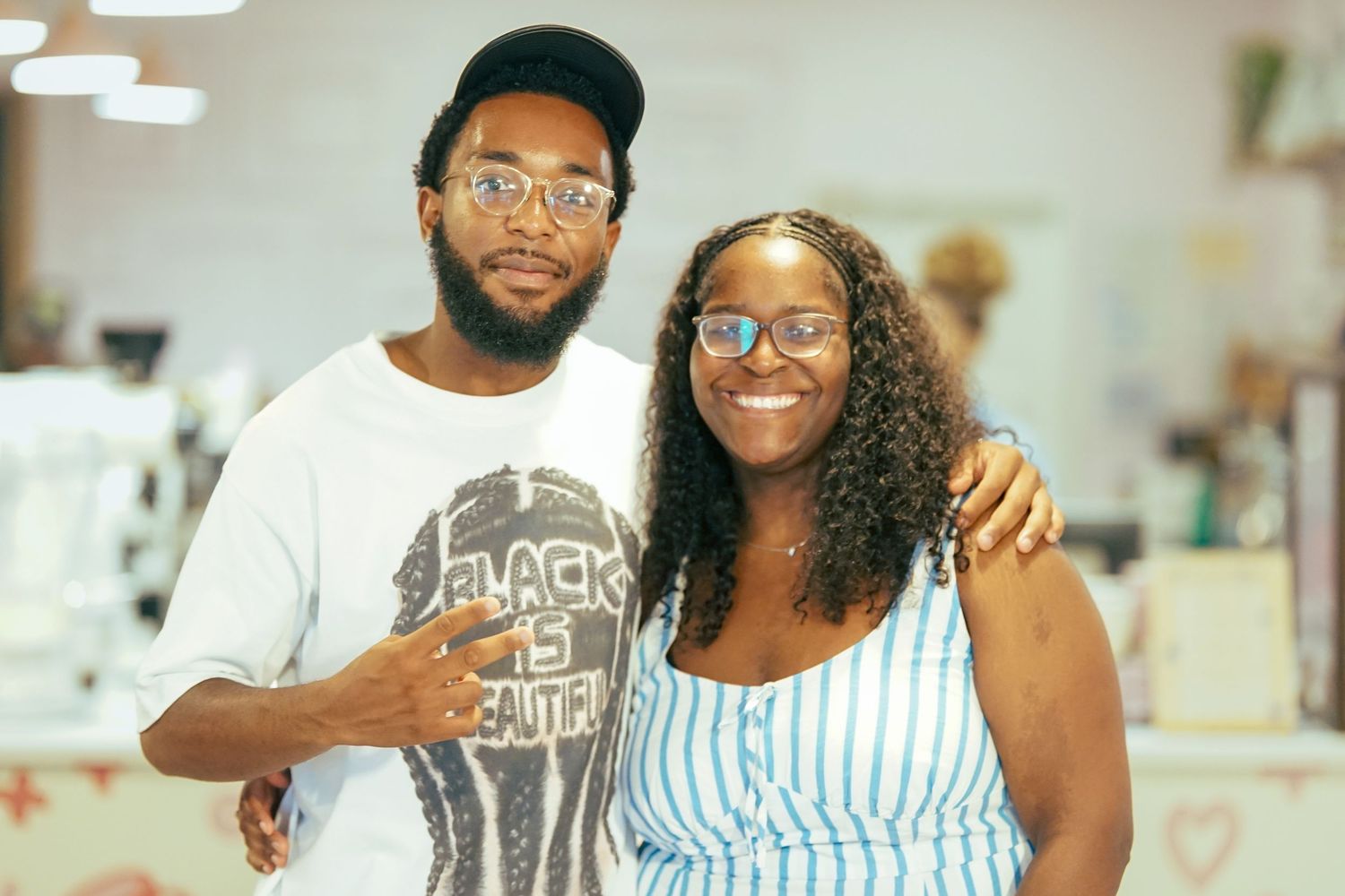 A smiling man and woman pose together for a photo at a casual indoor event.