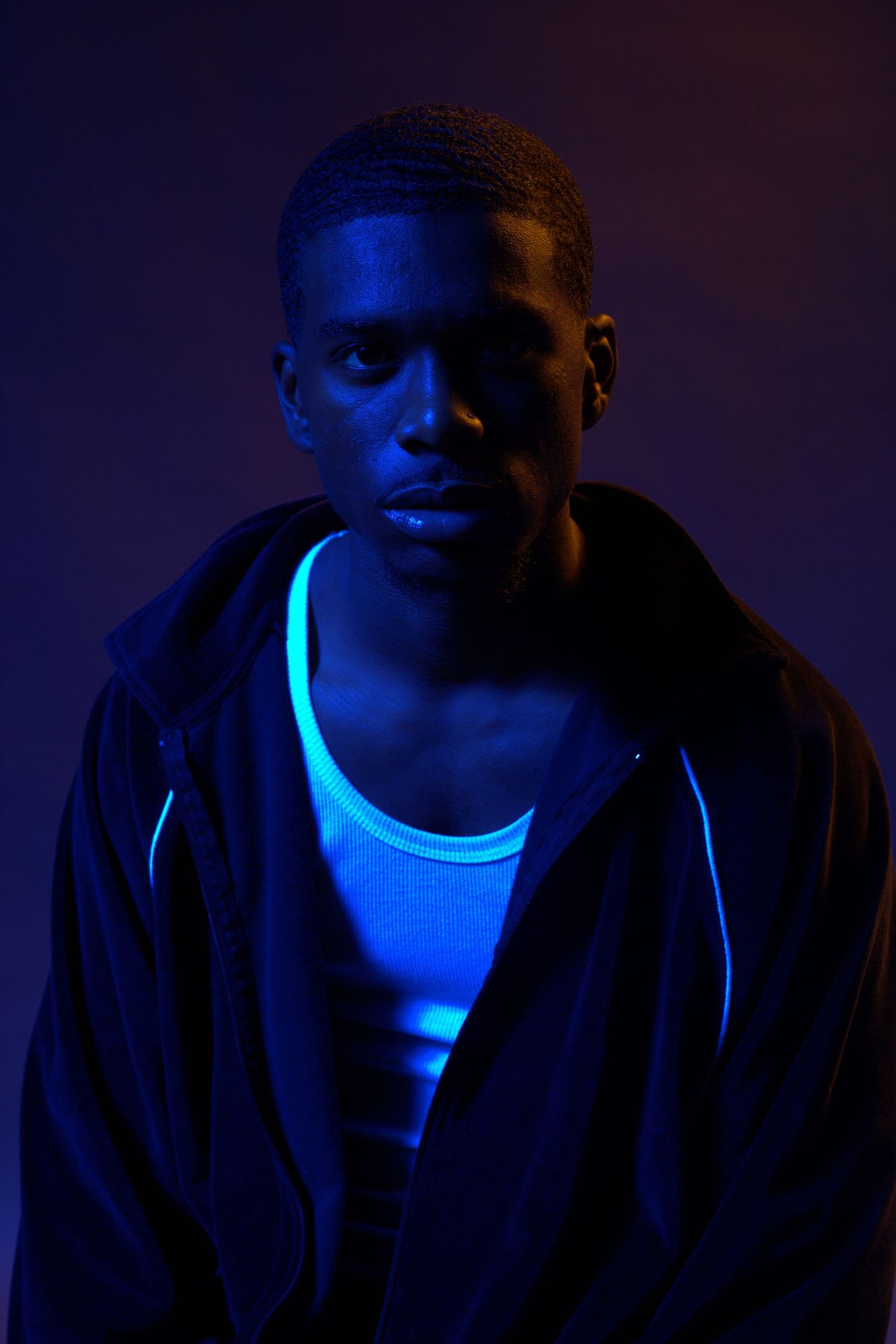 Dramatic portrait with blue lighting creating moody nighttime atmosphere.