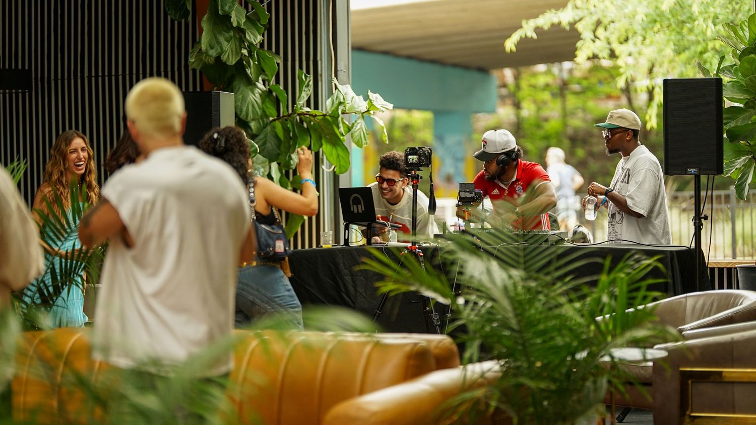 Event space decorated with green plants and vertical architectural elements creating depth and atmosphere.