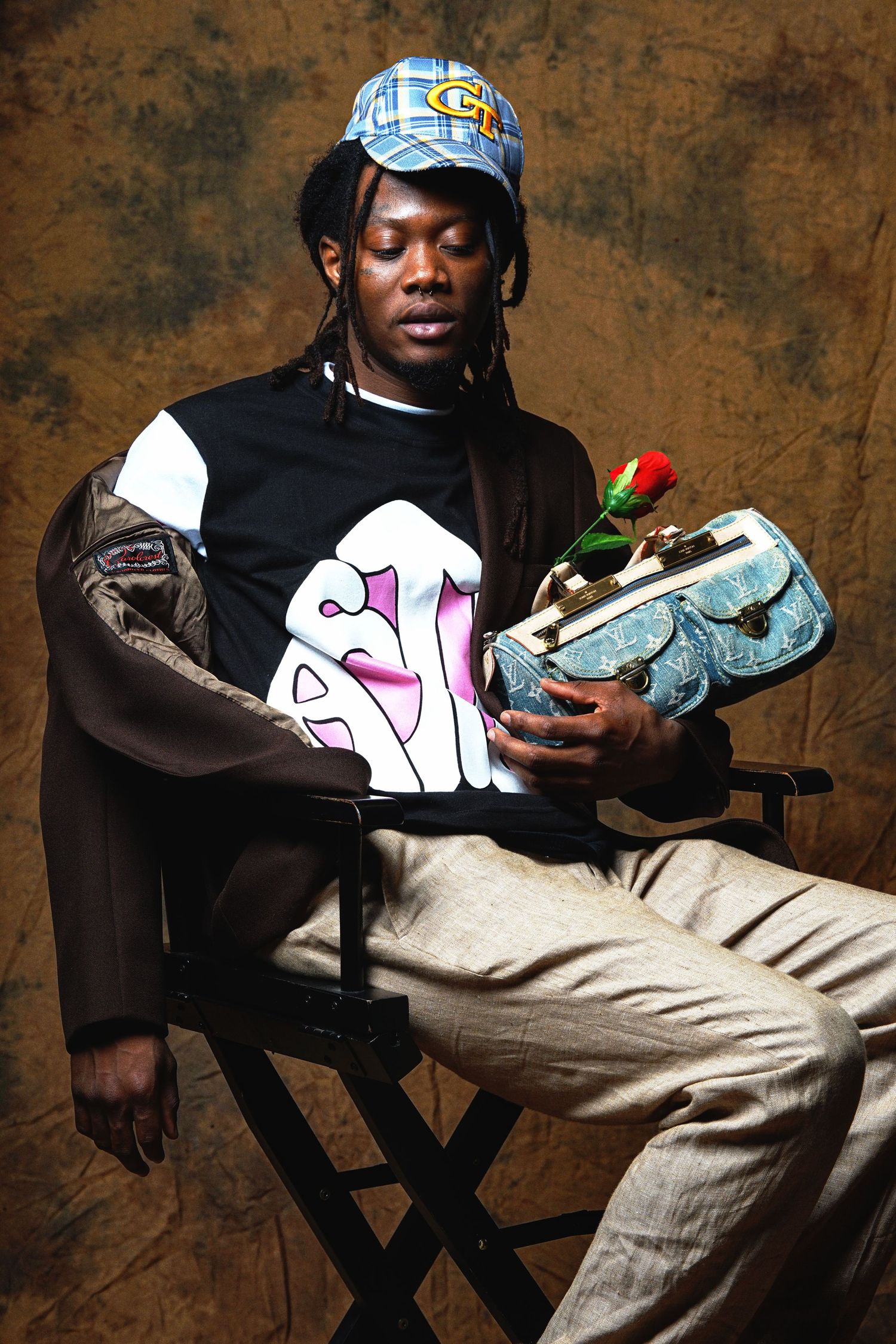 Fashion shoot featuring model with sneakers and casual wear in director's chair setting.