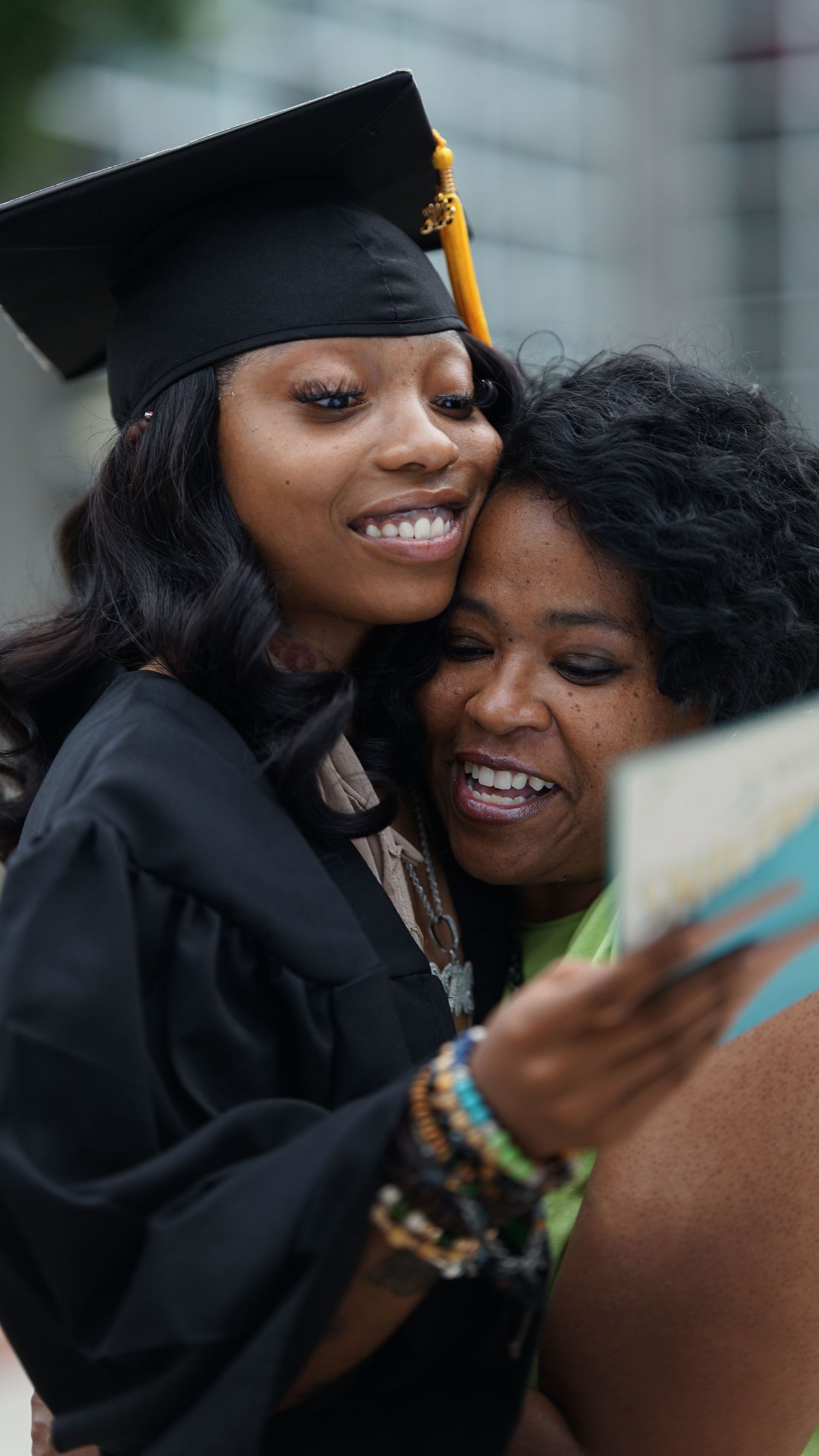 Graduate in black cap and gown shares joyful moment during celebration.