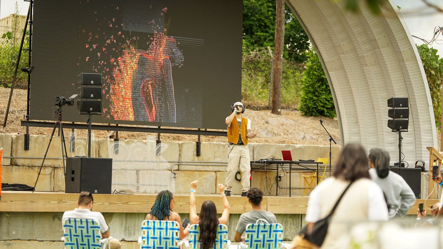 Crowd gathered at an outdoor venue with architectural elements visible in the background.