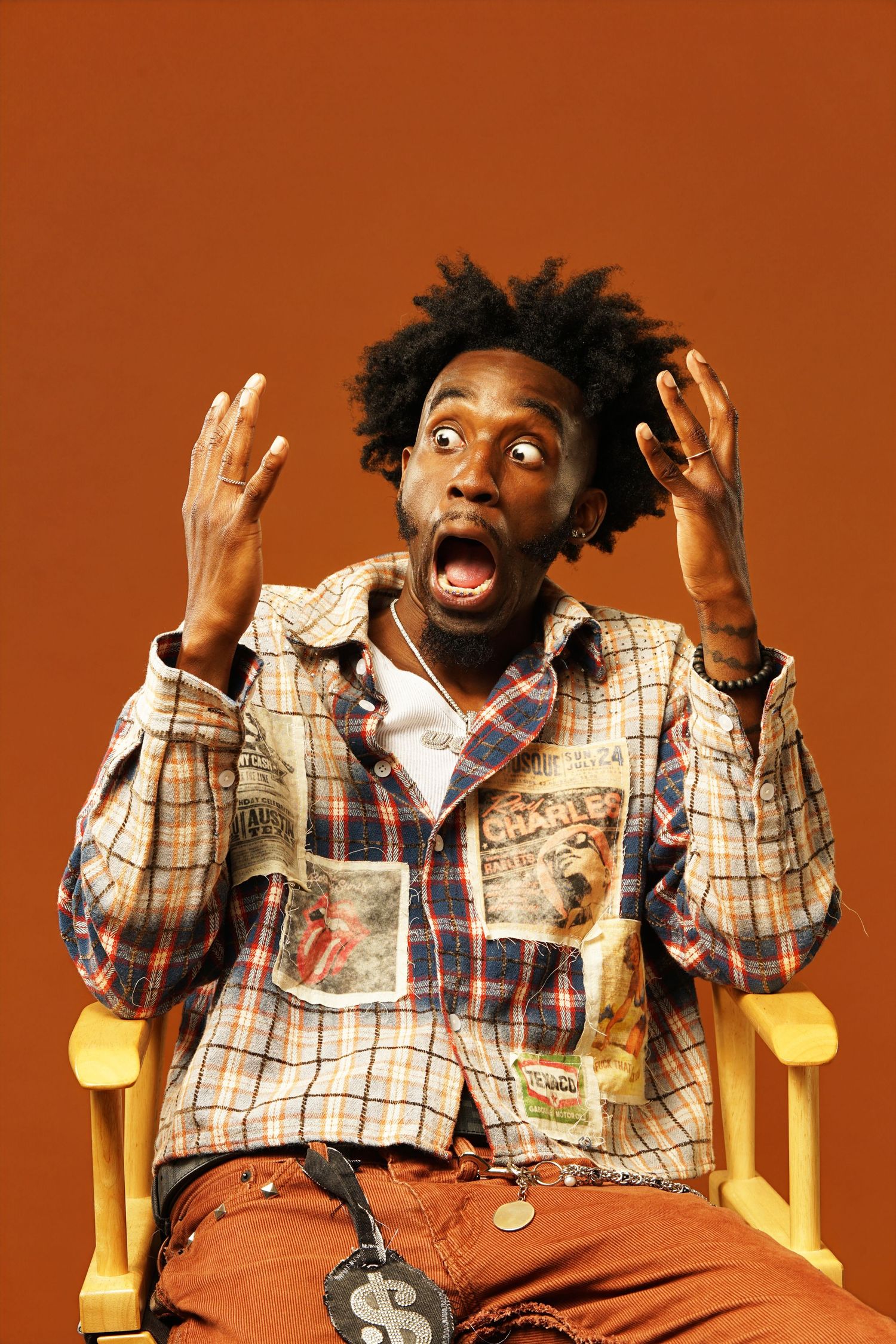 Energetic pose showing surprise and excitement while seated in yellow director's chair.