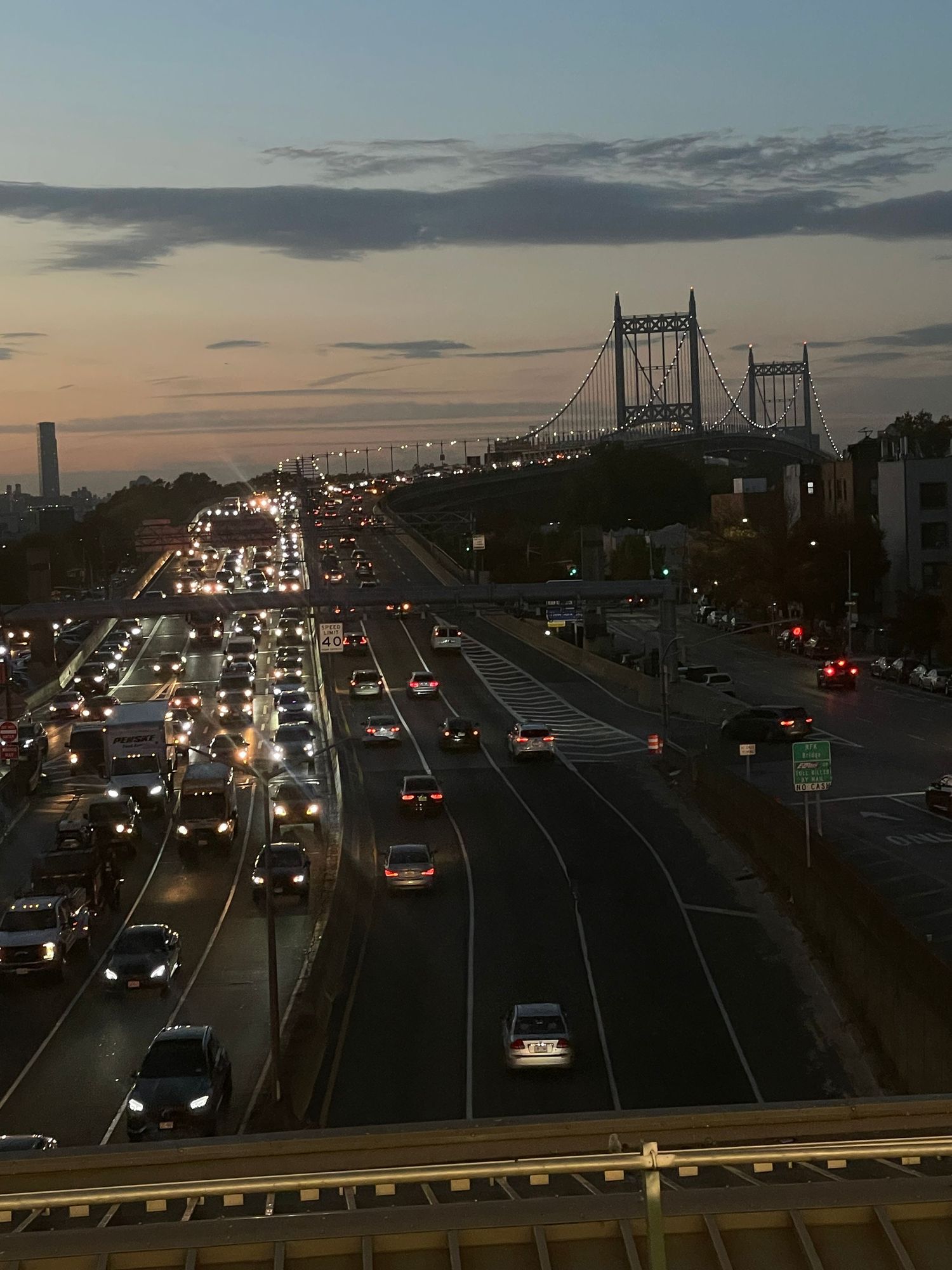 City bridge and highway at dusk with flowing traffic and illuminated roadways.
