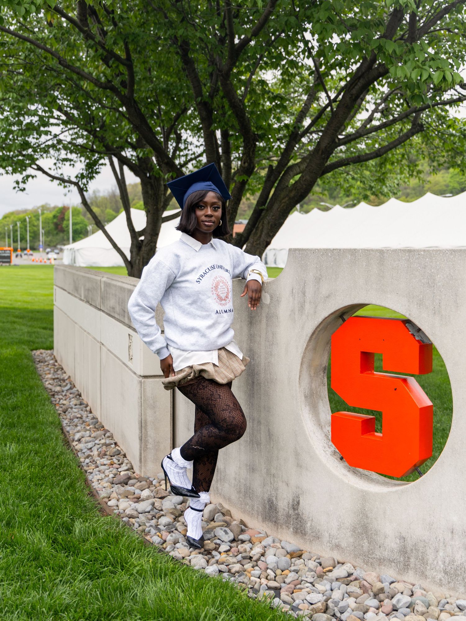 A sequence of images showing someone climbing through a bright orange number 5 cutout in a concrete wall outdoors.