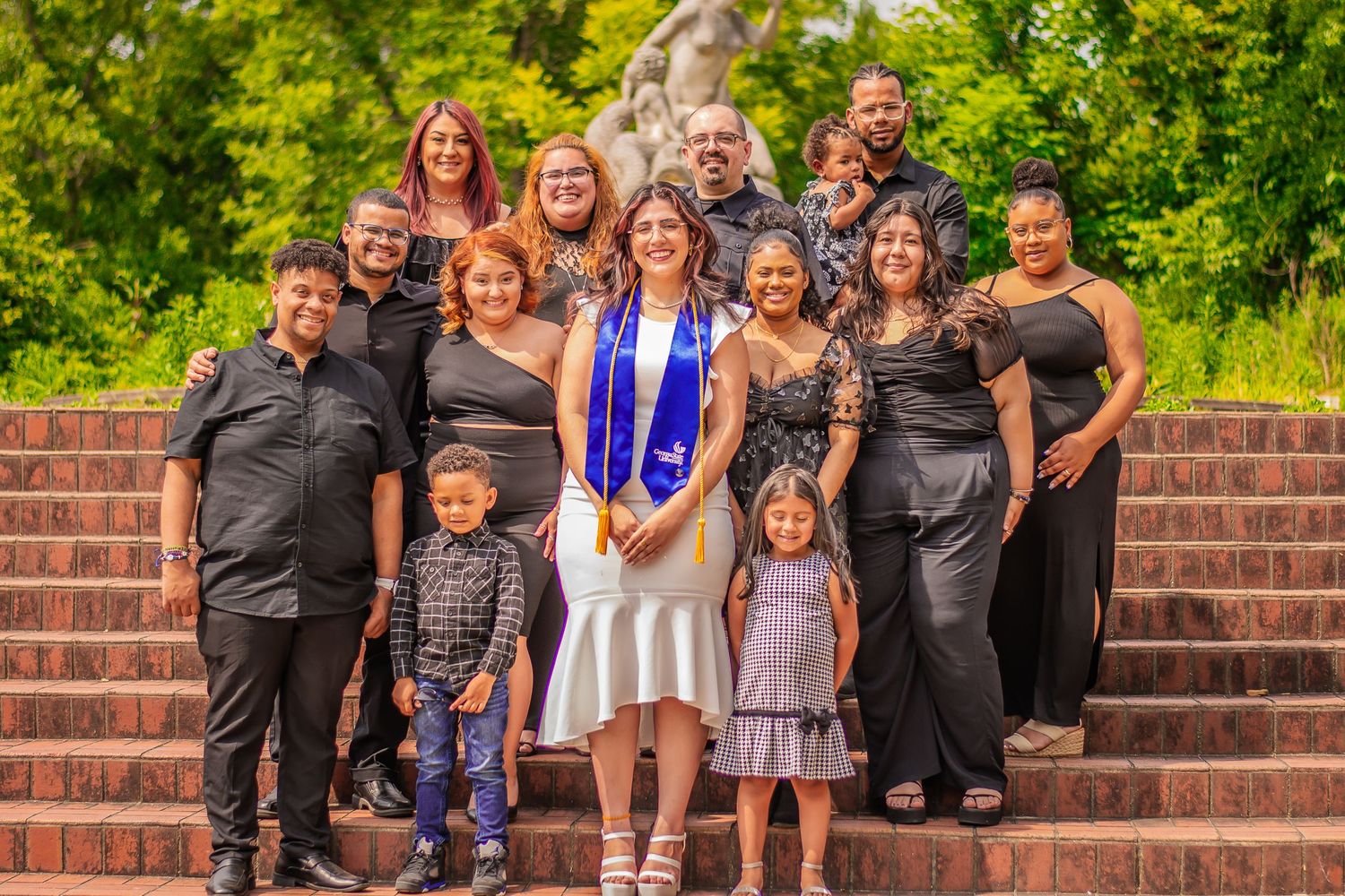 Group photo of family and friends celebrating graduation on brick steps.