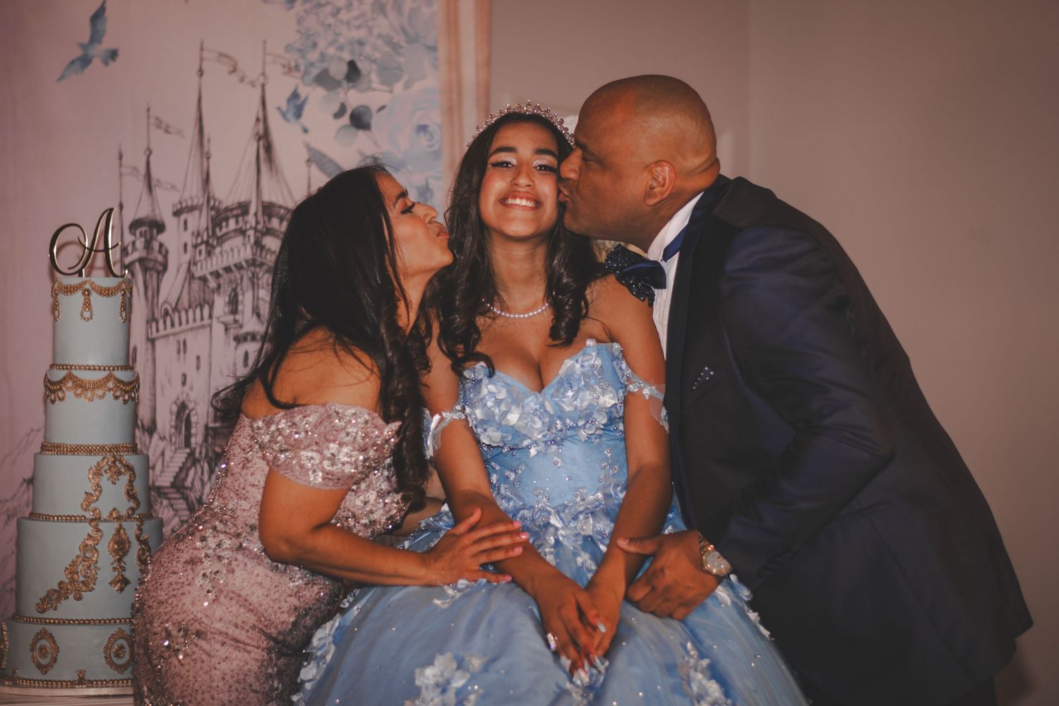 Sweet family moment during quinceañera celebration with blue gown and formal attire.