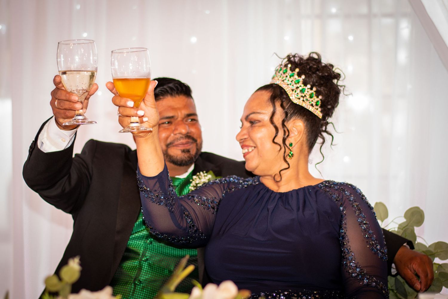Wedding celebration toast with champagne glasses and festive decorations.