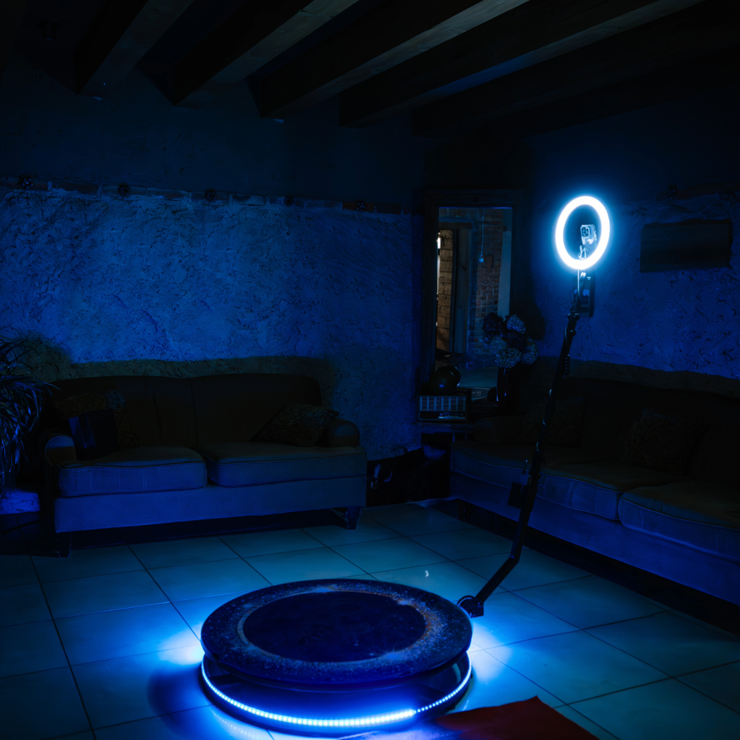 A blue-lit room with couches and professional lighting equipment.