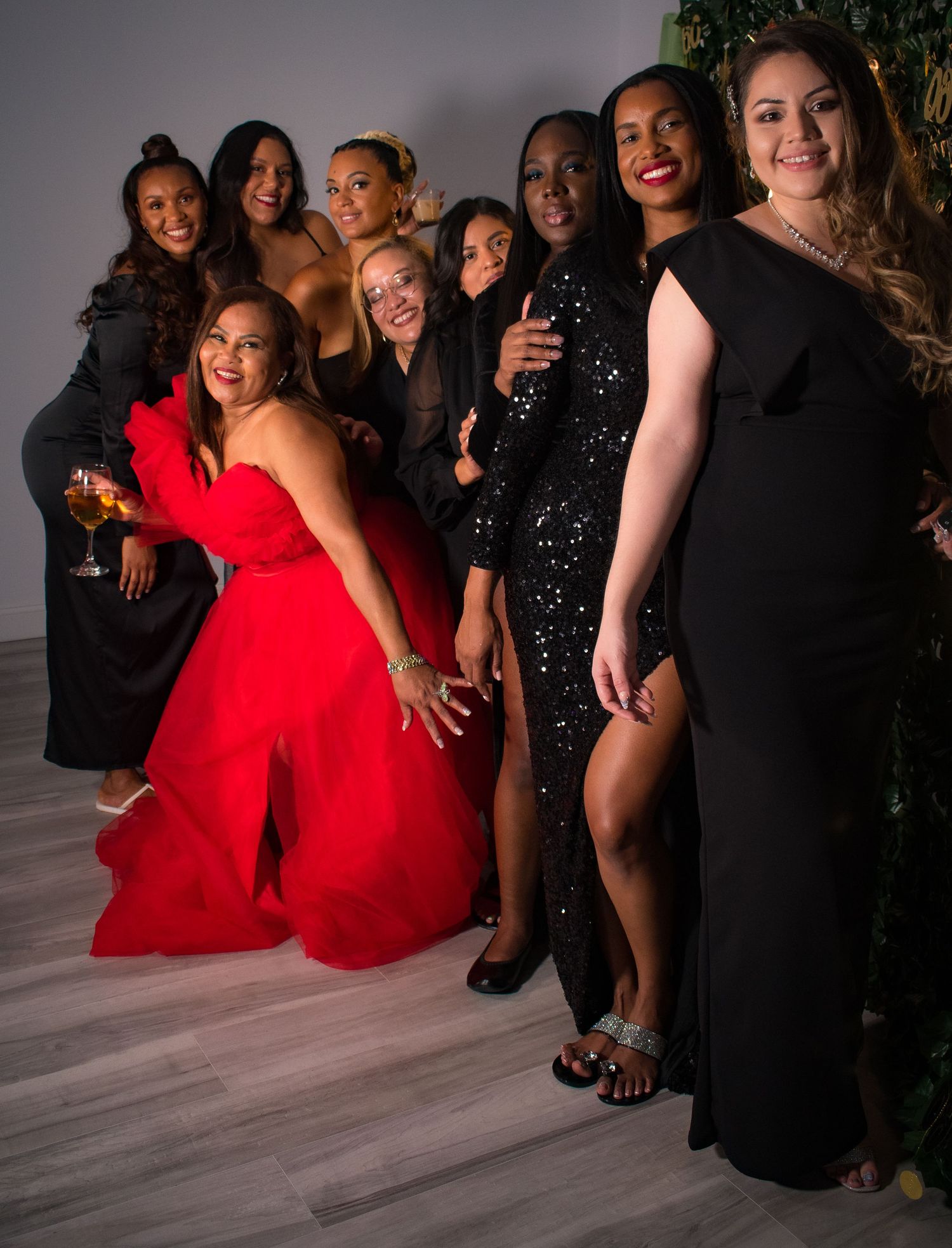Group of women in formal evening gowns pose together at an elegant event.