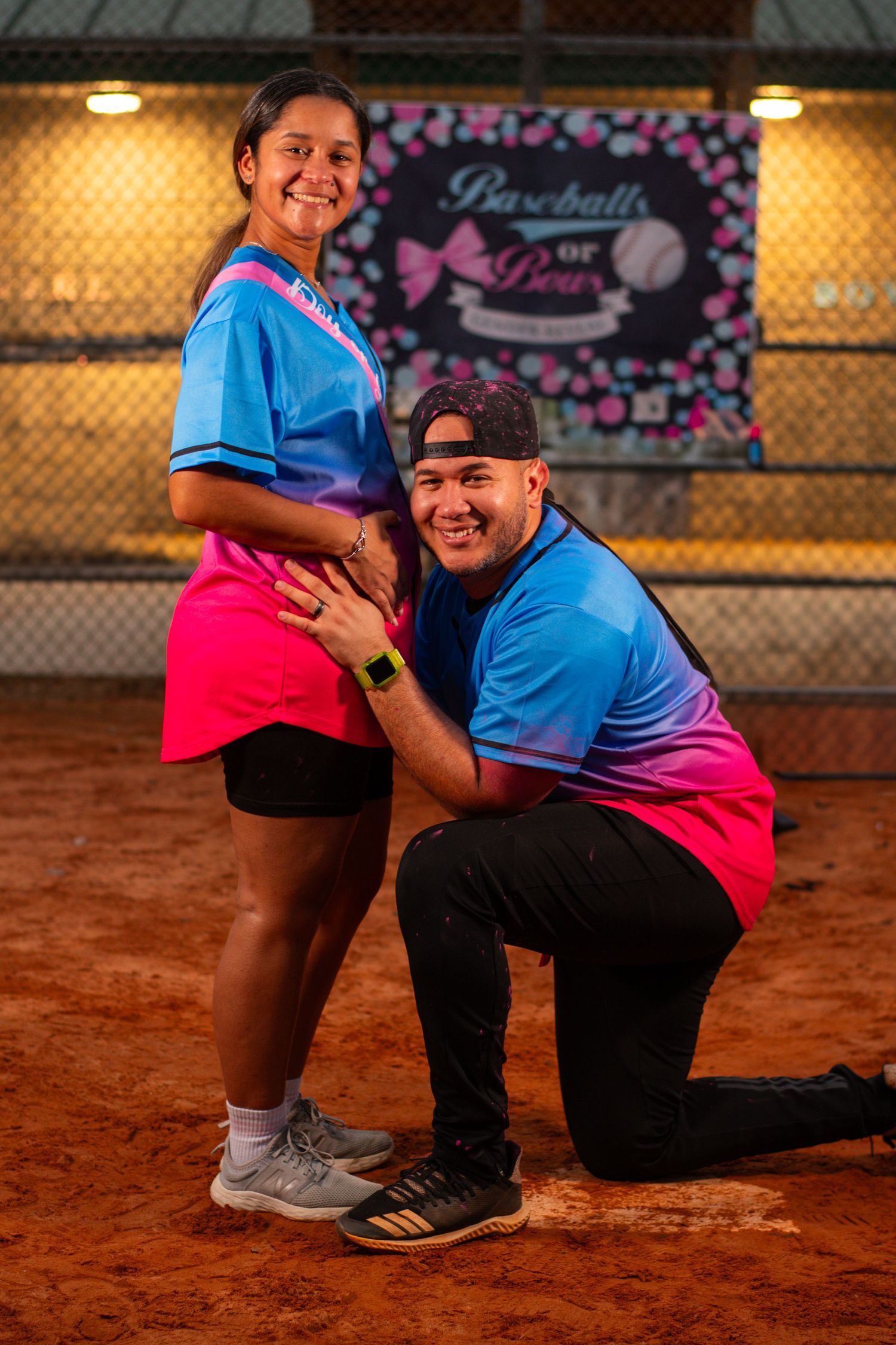A couple sharing a happy moment during a baseball field proposal.