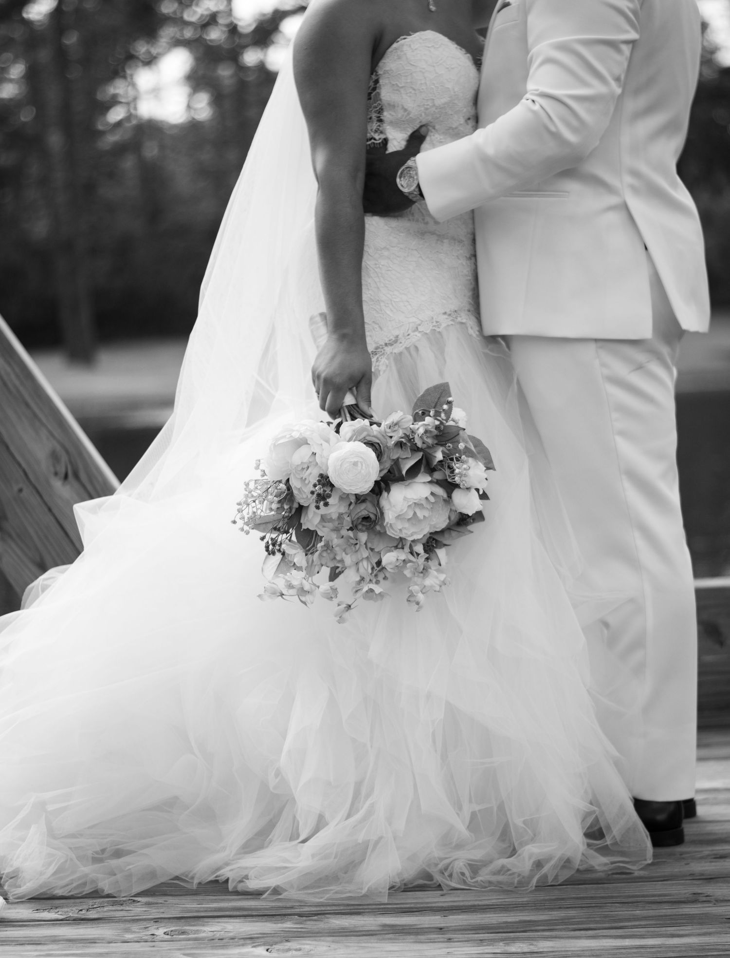 Candid wedding photography series showing elegant bride in flowing white dress holding bouquet against black and white backdrop.