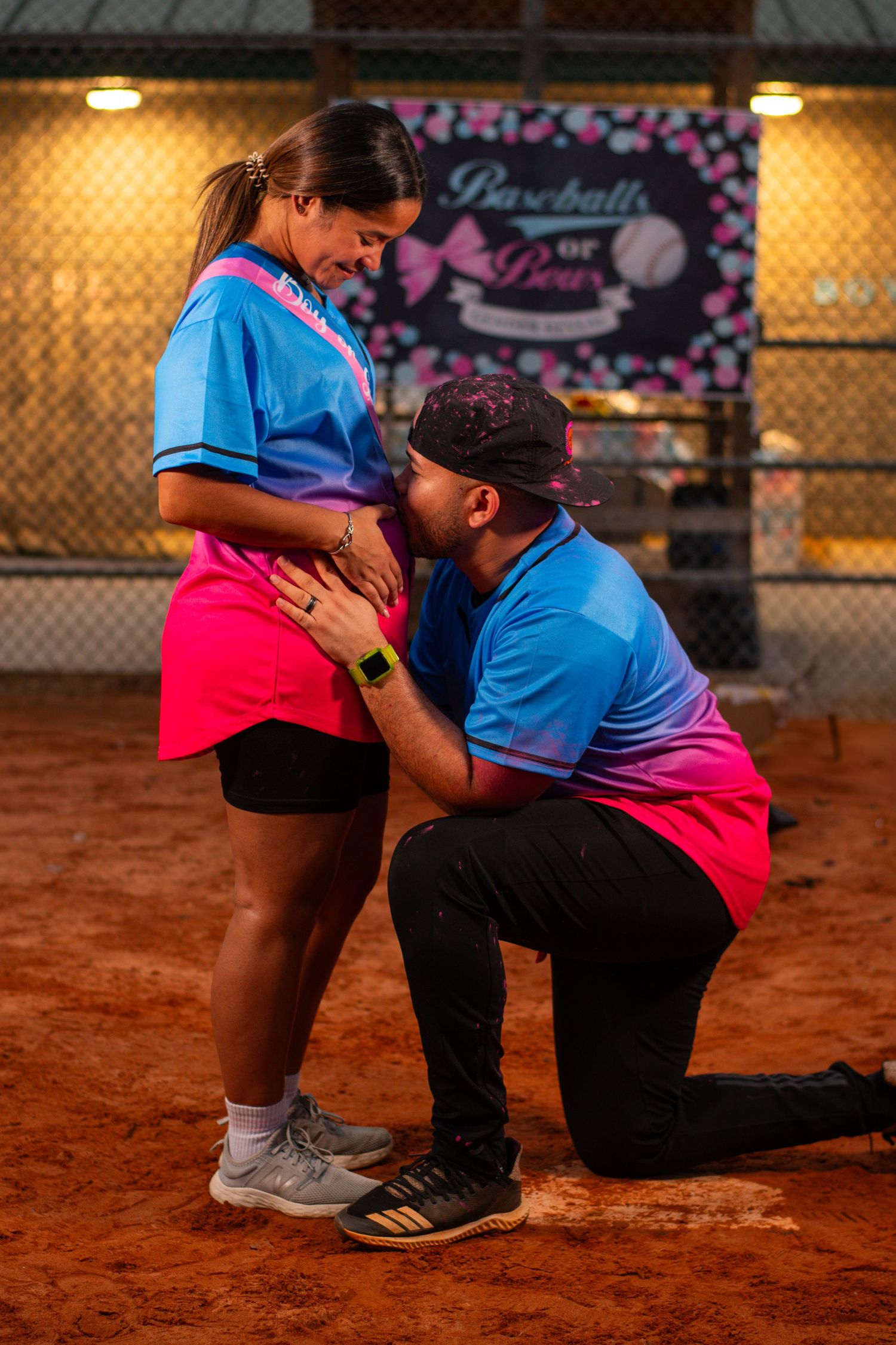 A romantic proposal moment on a baseball field with a decorative backdrop.