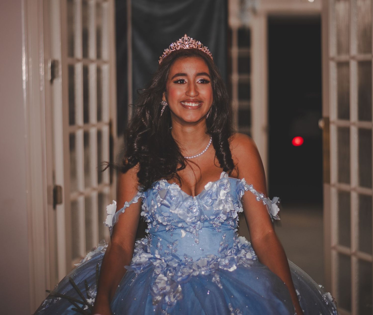 Celebration in blue embellished ballgown with tiara and crystal details.