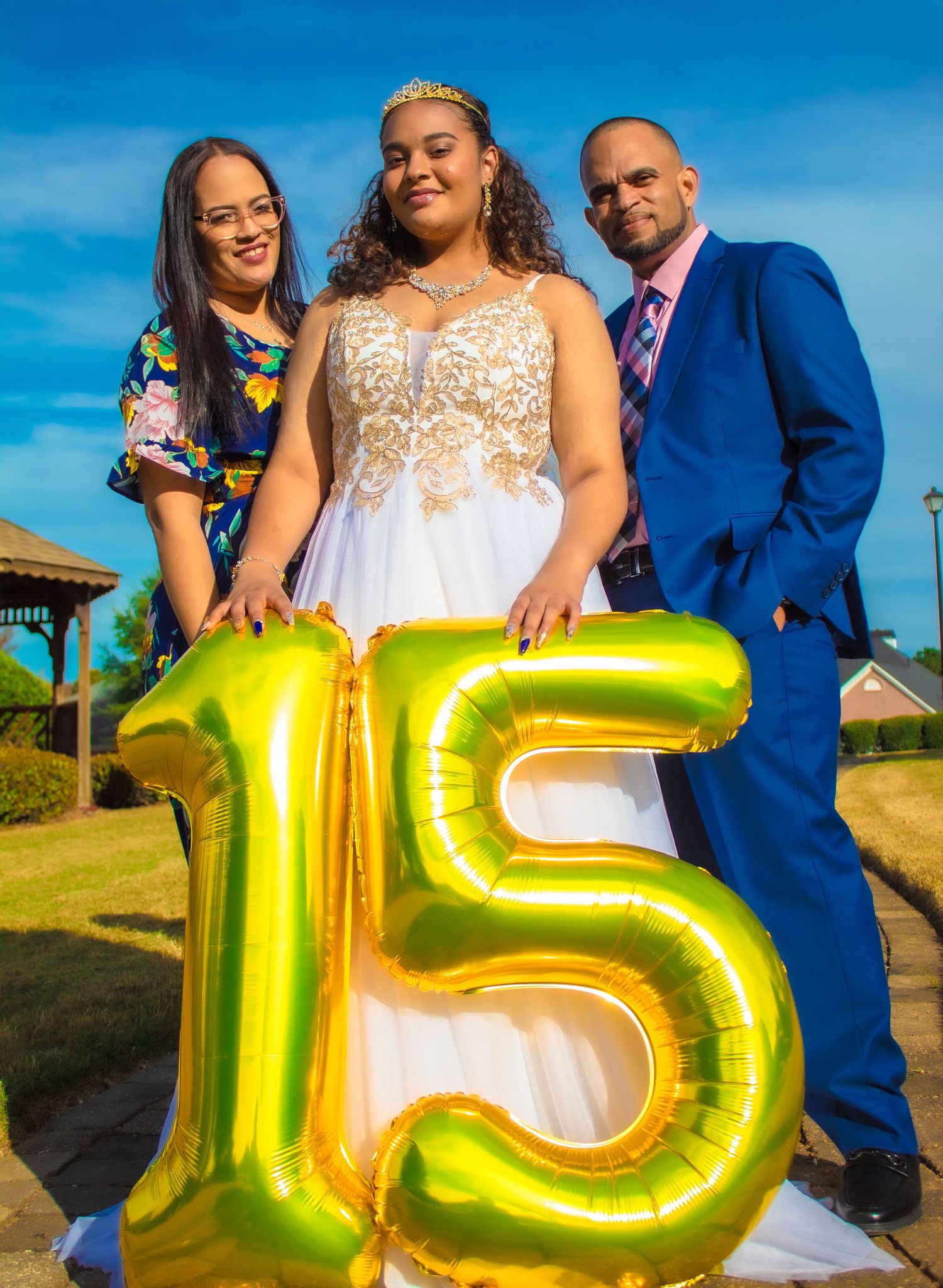 Celebration with large gold number 15 balloon in outdoor setting.
