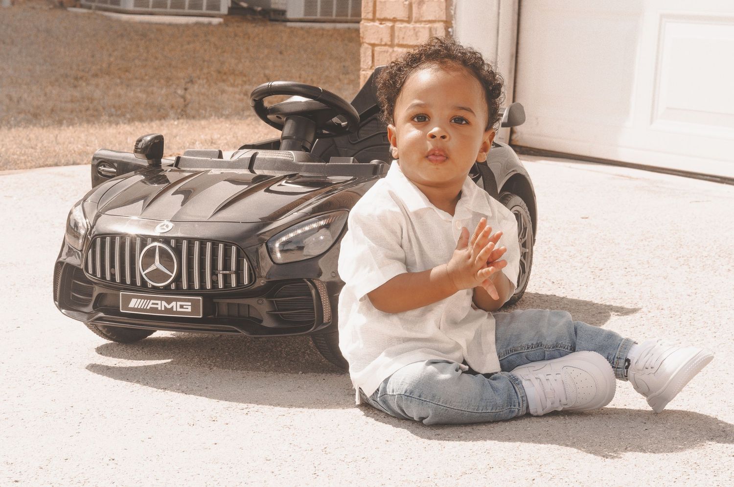 Four photos showing a sleek black sports car photographed from various angles on a sunny day.