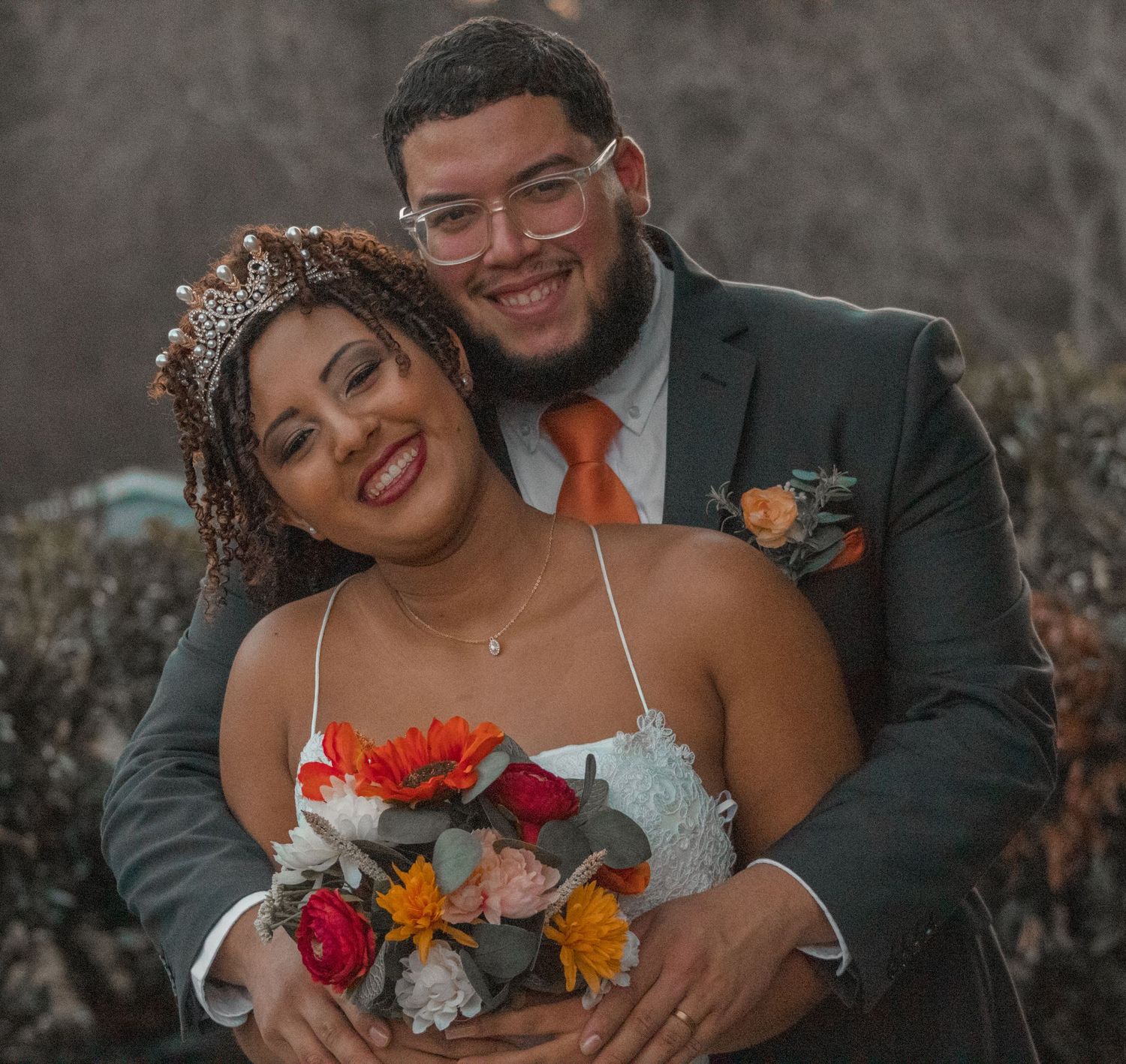 Close-up wedding photo of a couple sharing an intimate moment with bright floral bouquet.