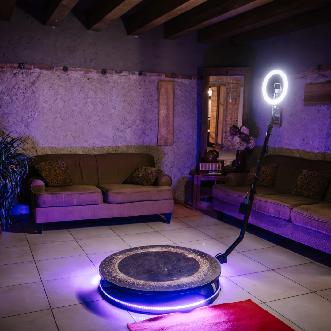A room with purple lighting featuring couches and a ring light setup for content creation.