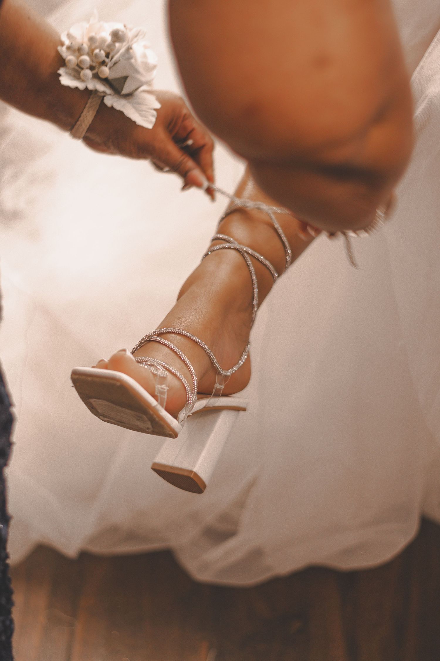 Close-up view of elegant bridal heels decorated with delicate pearls and crystals.