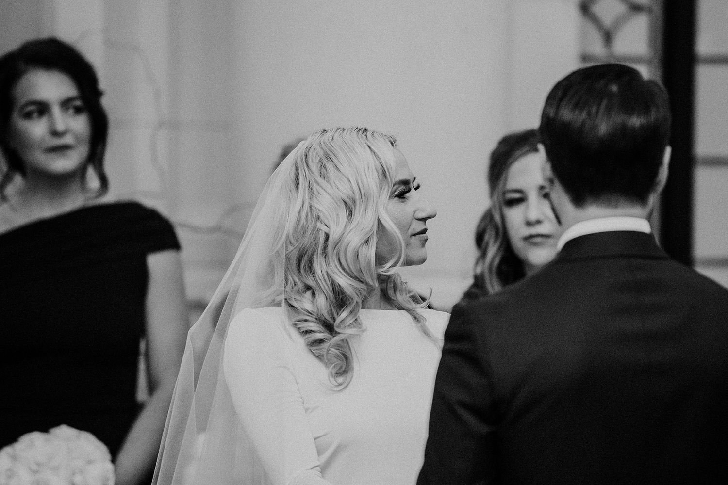 Black and white wedding photo showing a tender moment between a couple during their wedding ceremony.