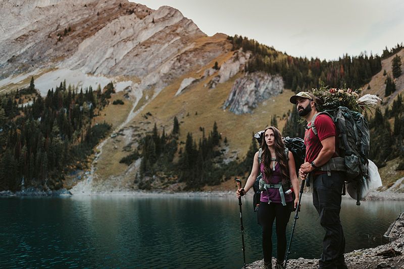 Adventurers hiking along scenic mountain trails near an alpine lake in the rugged wilderness.