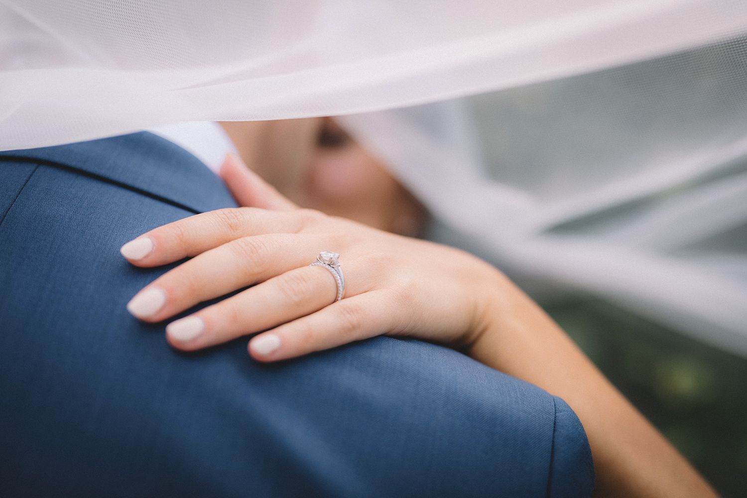 Two hands gently touch in a comforting gesture against a soft, blurred background.