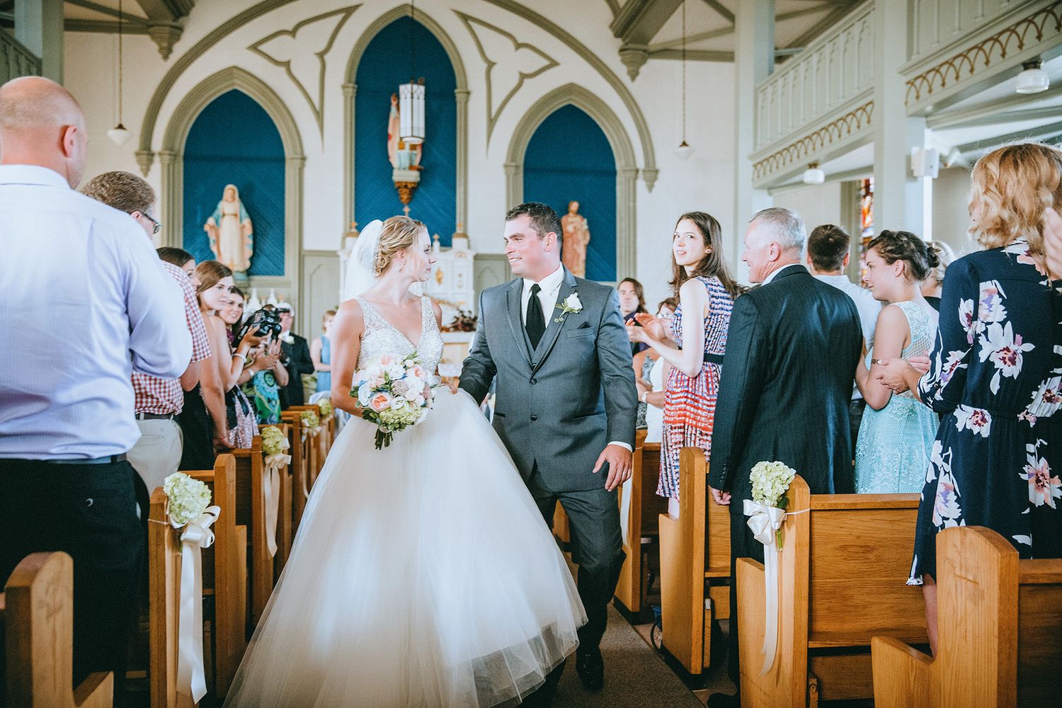 A bride and groom's church wedding ceremony photos showing guests in pews and decorative architectural details.
