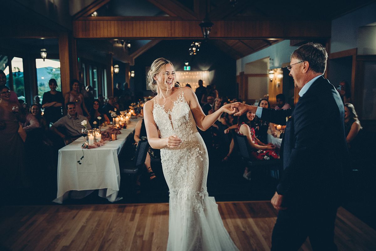 Couples dance together on a dimly lit dance floor during an elegant wedding reception celebration at the Harvest Golf Club in Kelowna.