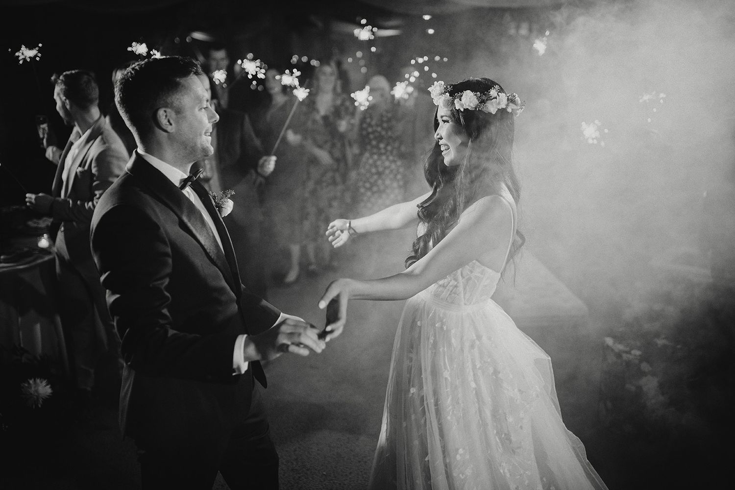 A couple dances together at a wedding reception surrounded by atmospheric fog and sparklers on the dance floor at 19 Green golf course.