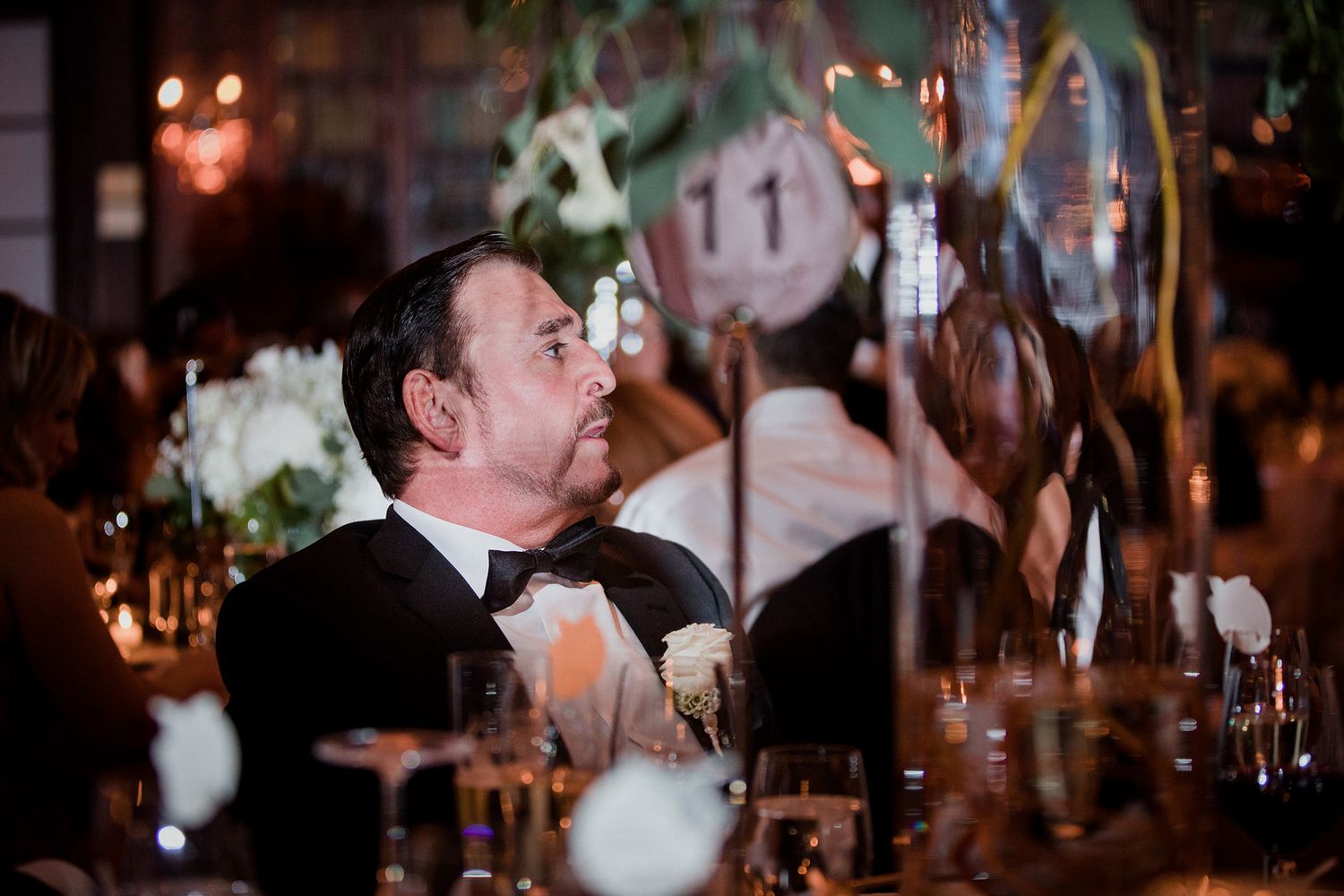 Romantic moments captured at a dimly lit wedding reception with soft glowing lights in the background.