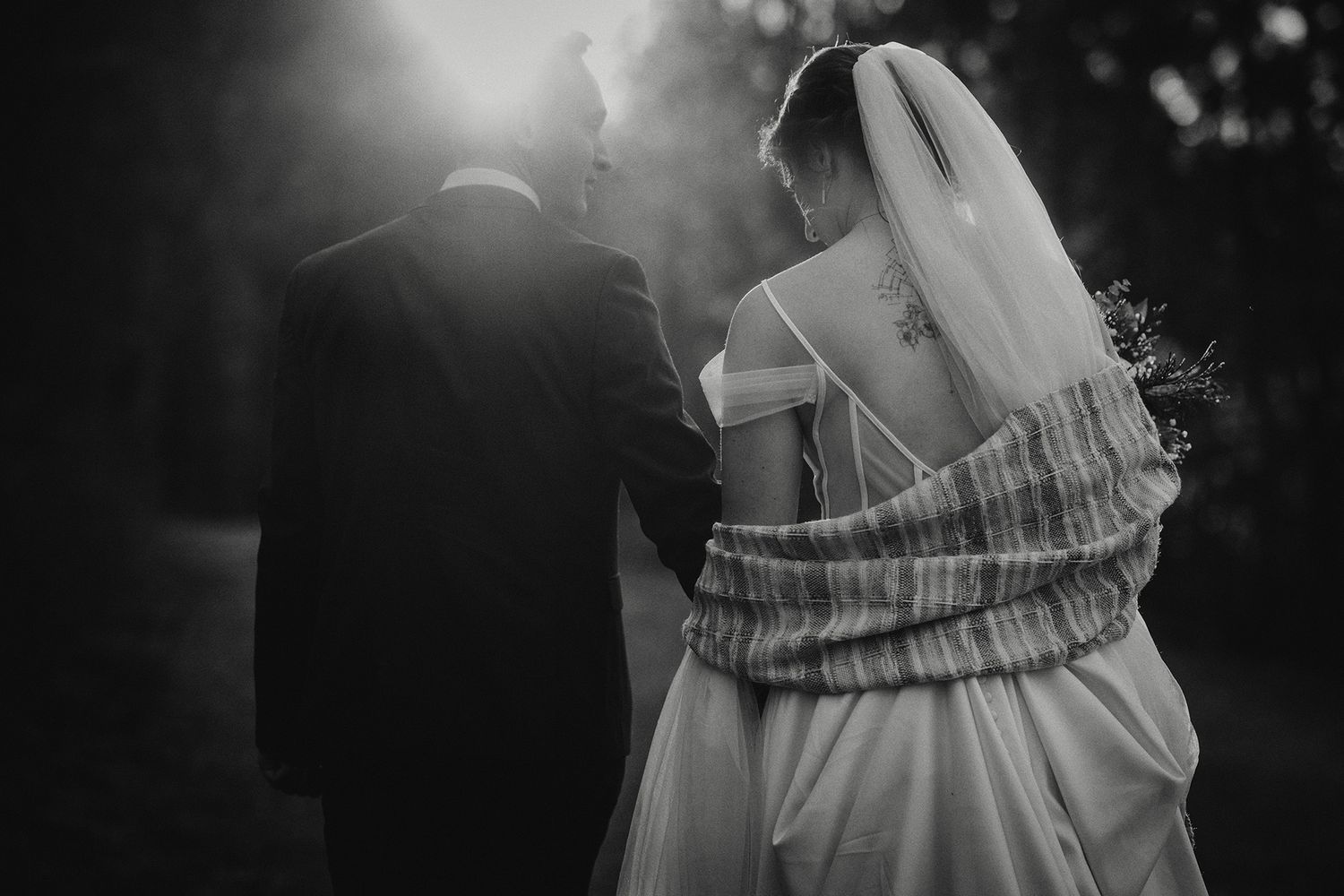 Black and white artistic wedding photos showing romantic moments between a couple in formal attire.