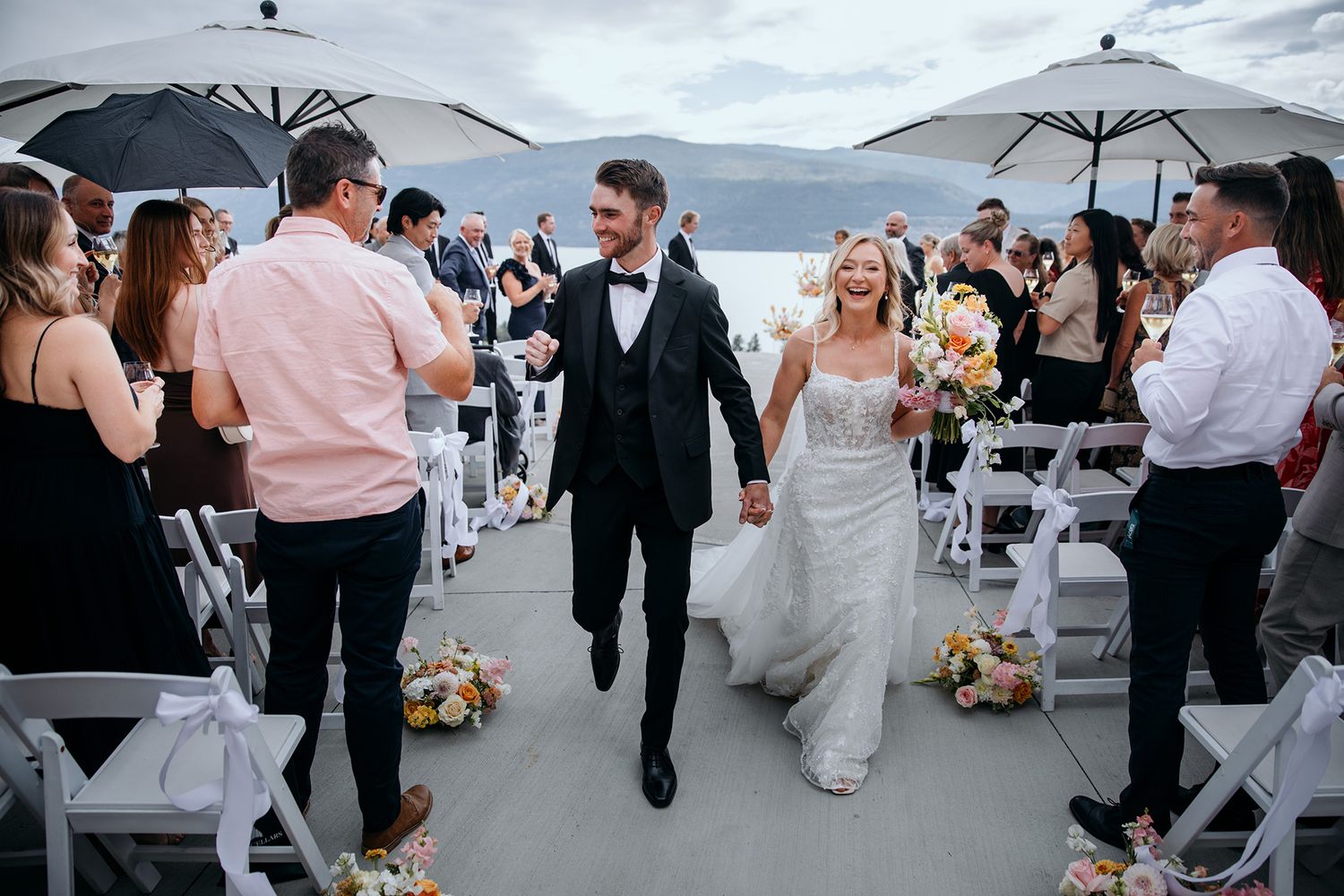 A bride and groom cheer as the exit their wedding ceremony.