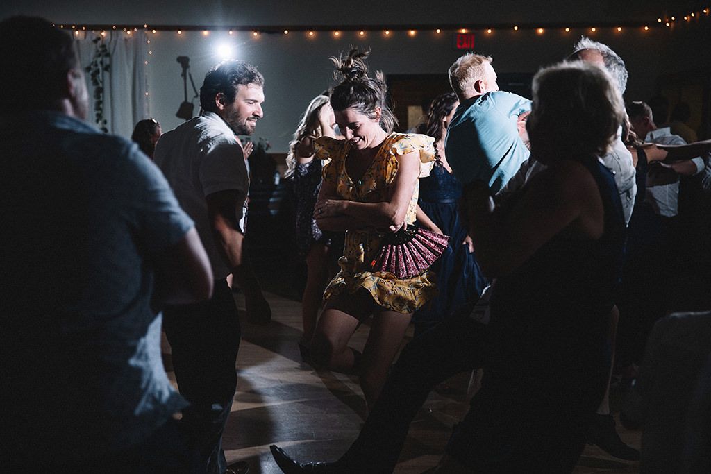 People dancing together in a dimly lit room with string lights creating a romantic atmosphere.