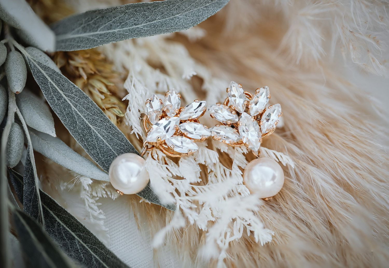 Decorative white snowflake ornaments and fluffy beige feathers arranged on a rustic wooden surface.