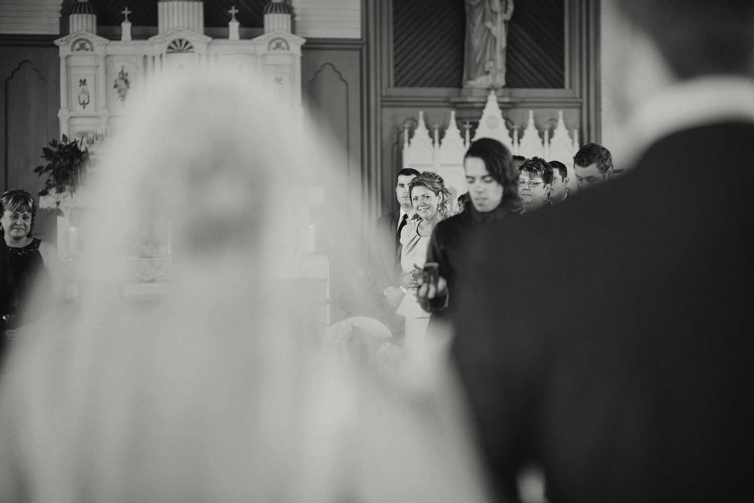 A black and white wedding scene shows a couple celebrating with guests during their reception.