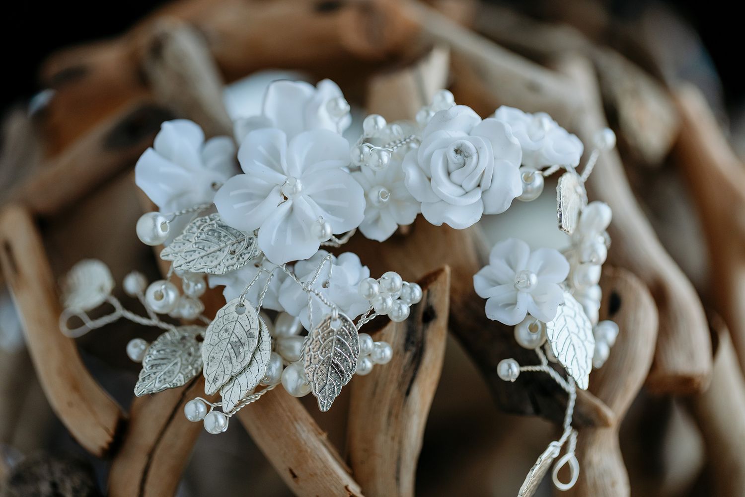 Delicate white orchids and roses arranged with crystal beads and pearls in an elegant wedding hair piece.