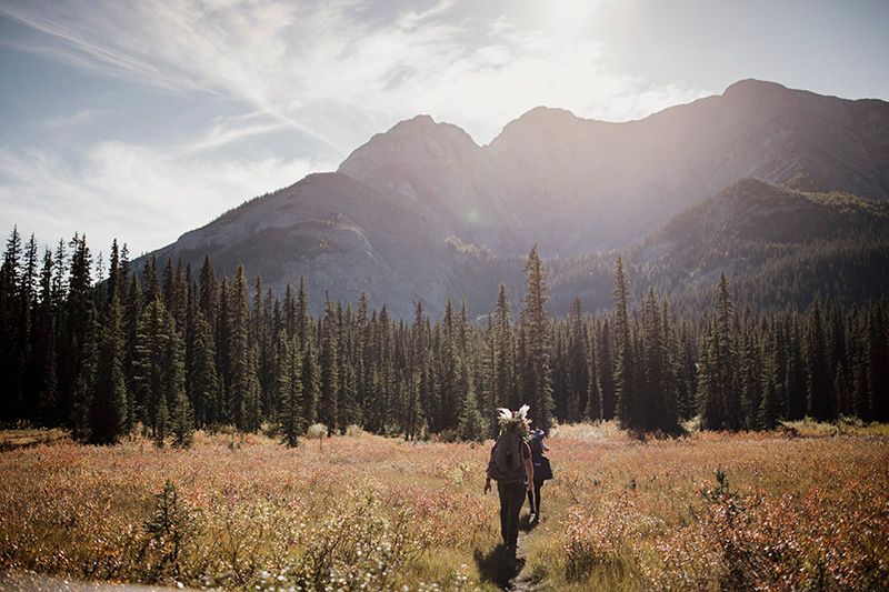 Scenic mountain landscape with golden sunlight streaming over peaks and evergreen forest in the wilderness.