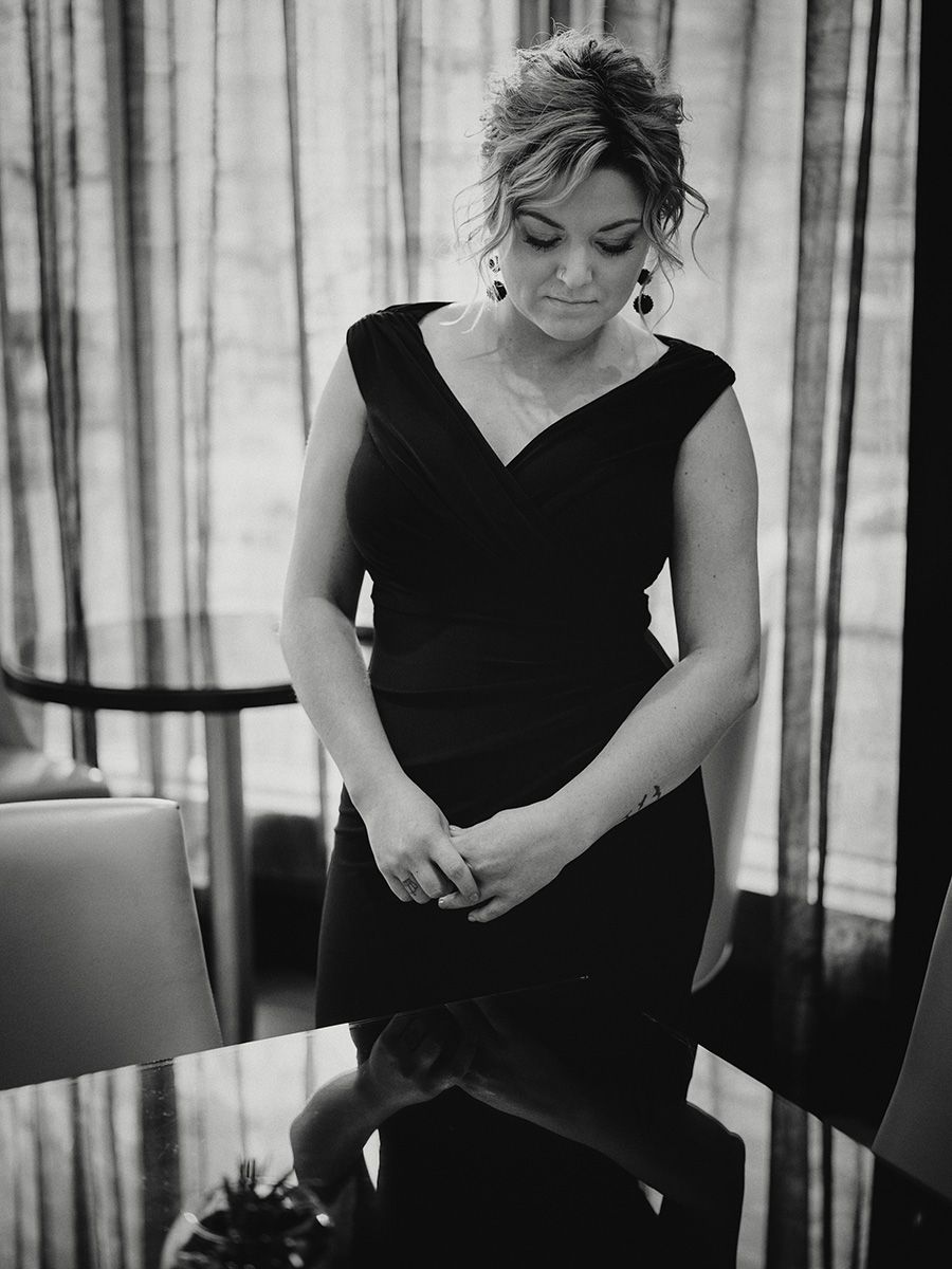 Black and white series of candid photos showing a woman in a black top looking down and smiling in different poses.