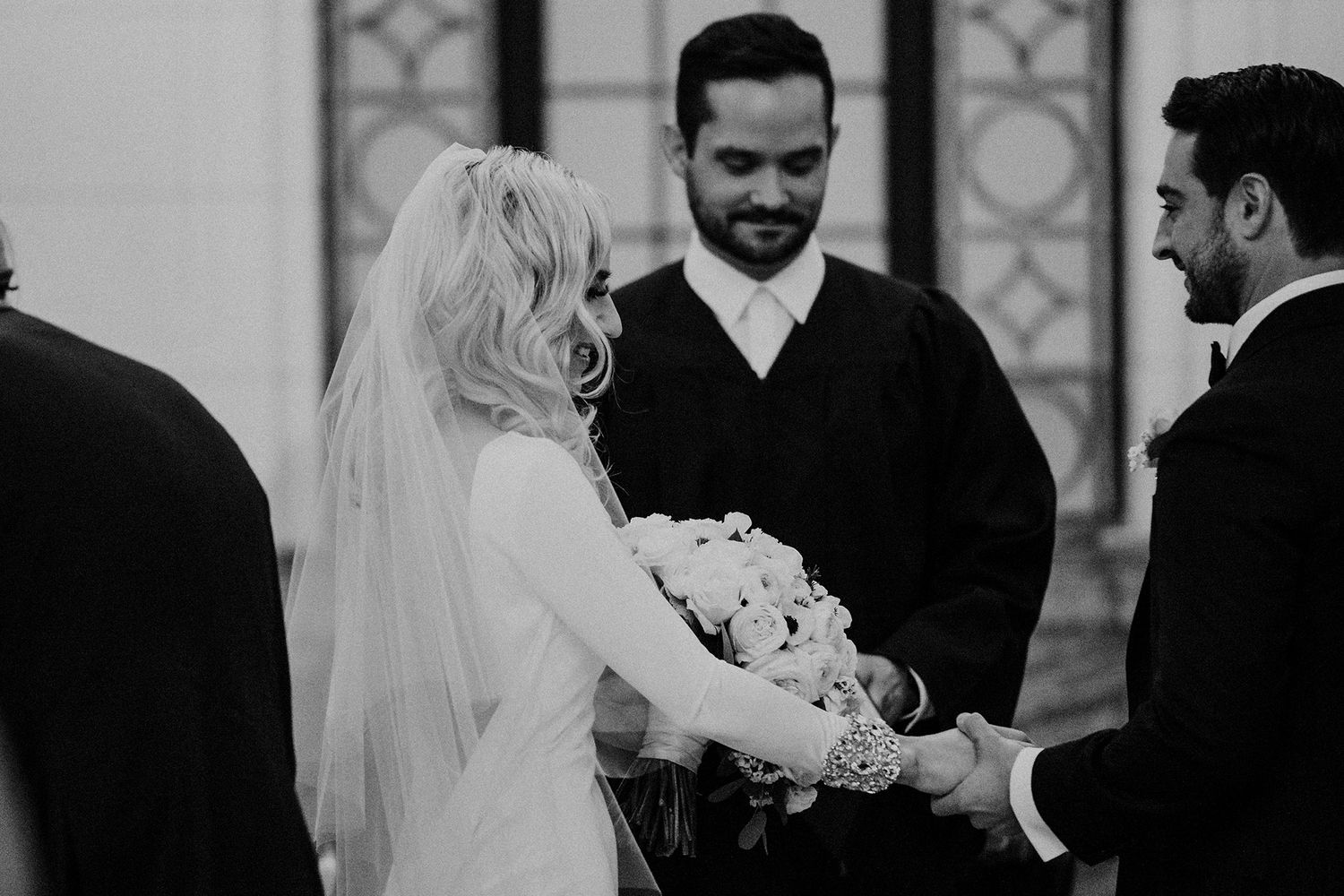 Black and white wedding photograph showing intimate moments between a couple during their ceremony.