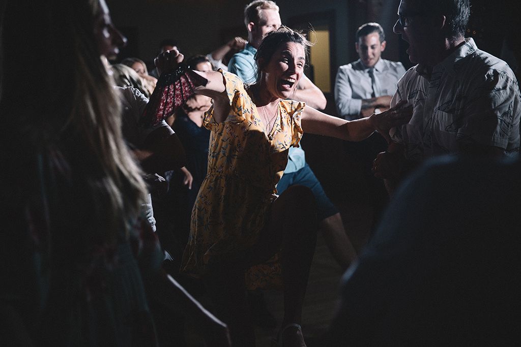 People dancing together in a dimly lit space with dramatic lighting creating a moody atmosphere.