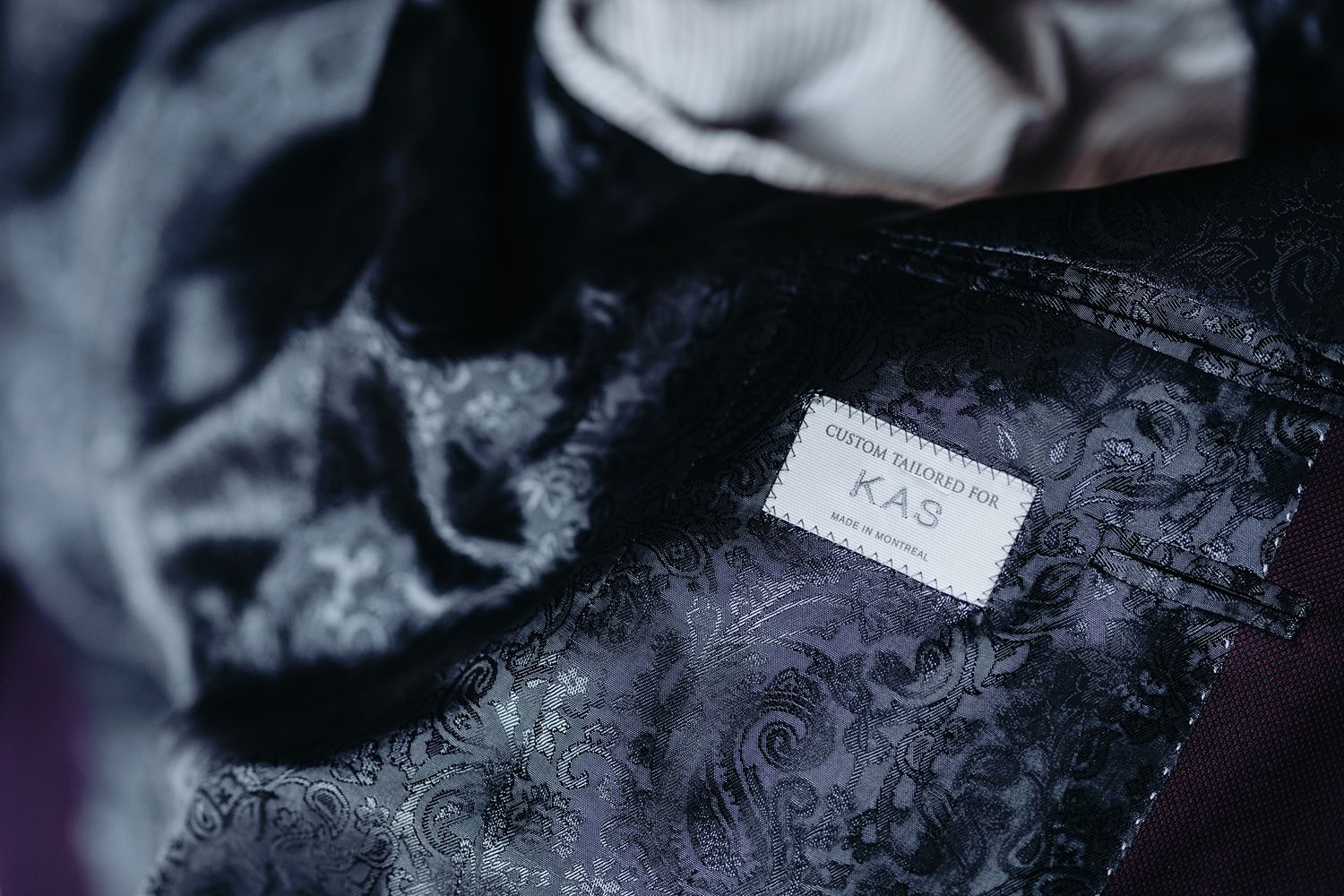 Close-up macro photograph of delicate white lace fabric showing intricate floral patterns and textures.