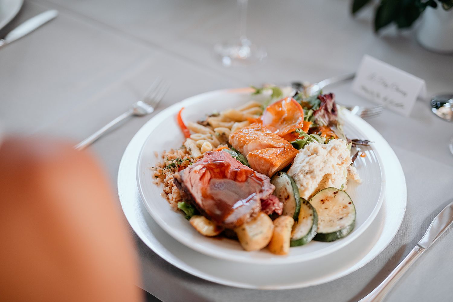 A plate of fresh seafood and vegetables arranged in a line on white plates against a light background.
