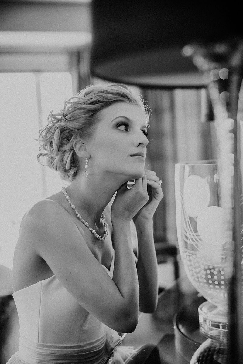 A black and white photo of a bride looking in a mirror with dramatic expressions in a cinematic style.