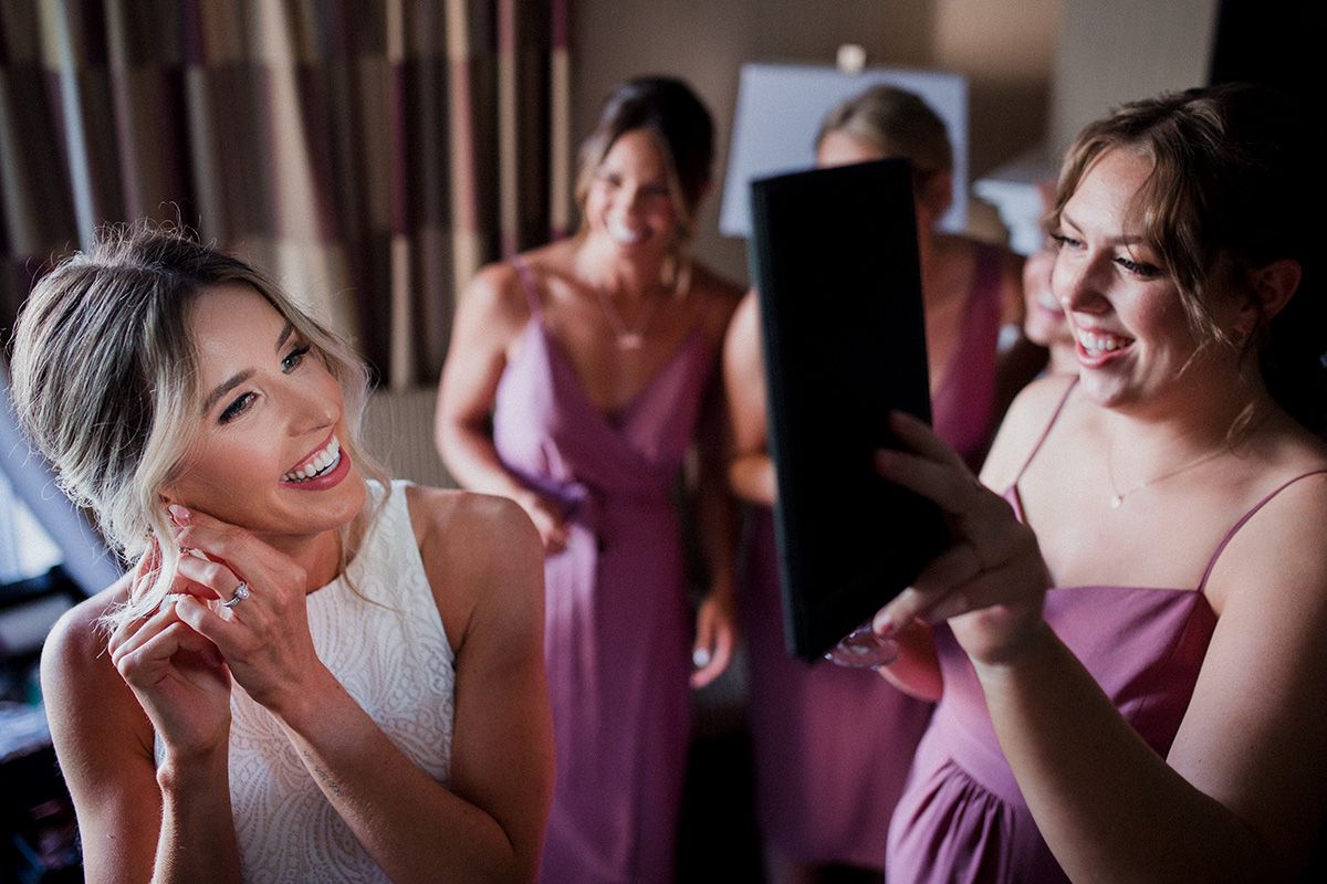 Wedding party members in pink dresses help with final preparations and getting ready before the ceremony.