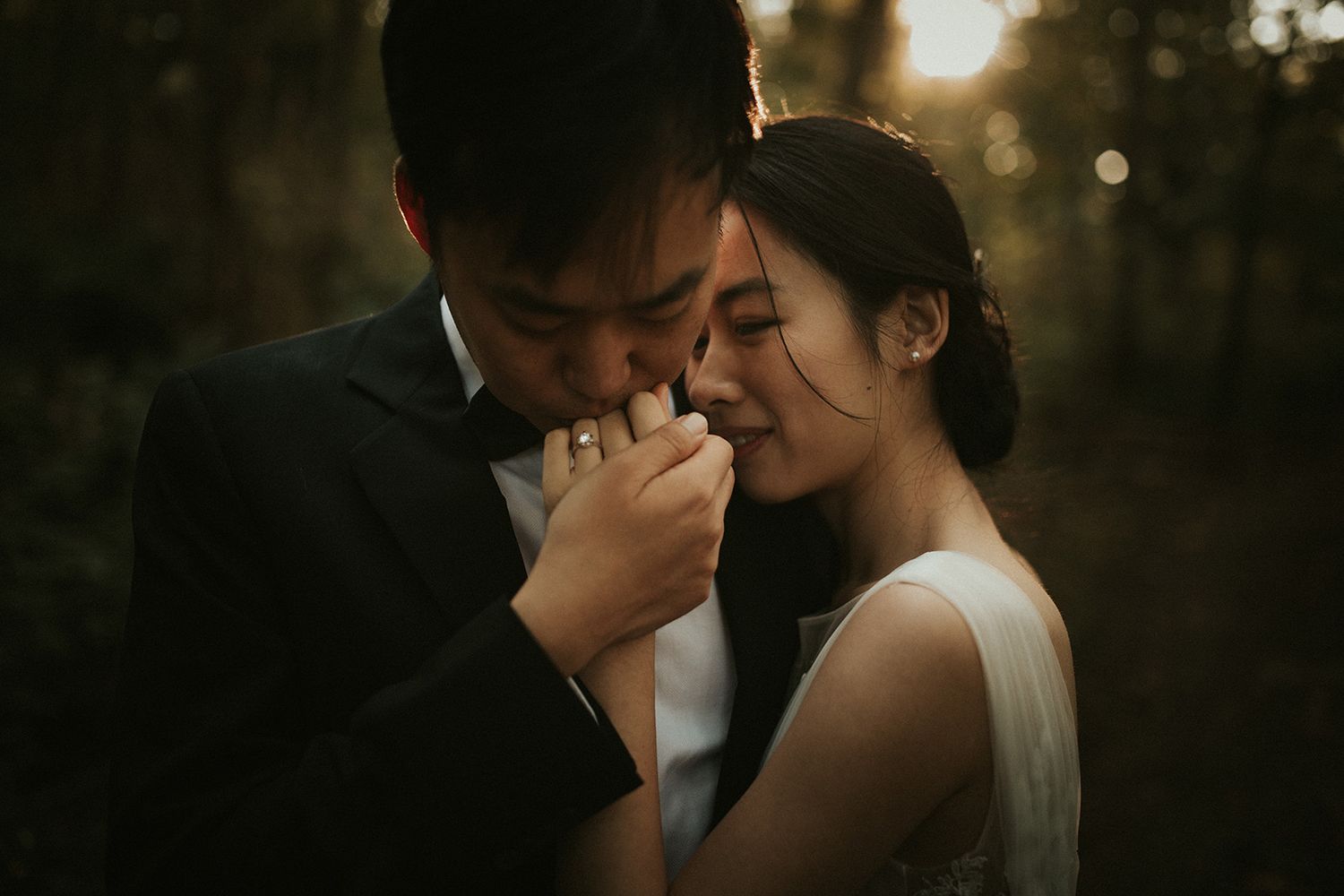 A couple shares an intimate moment at sunset in a romantic outdoor setting.