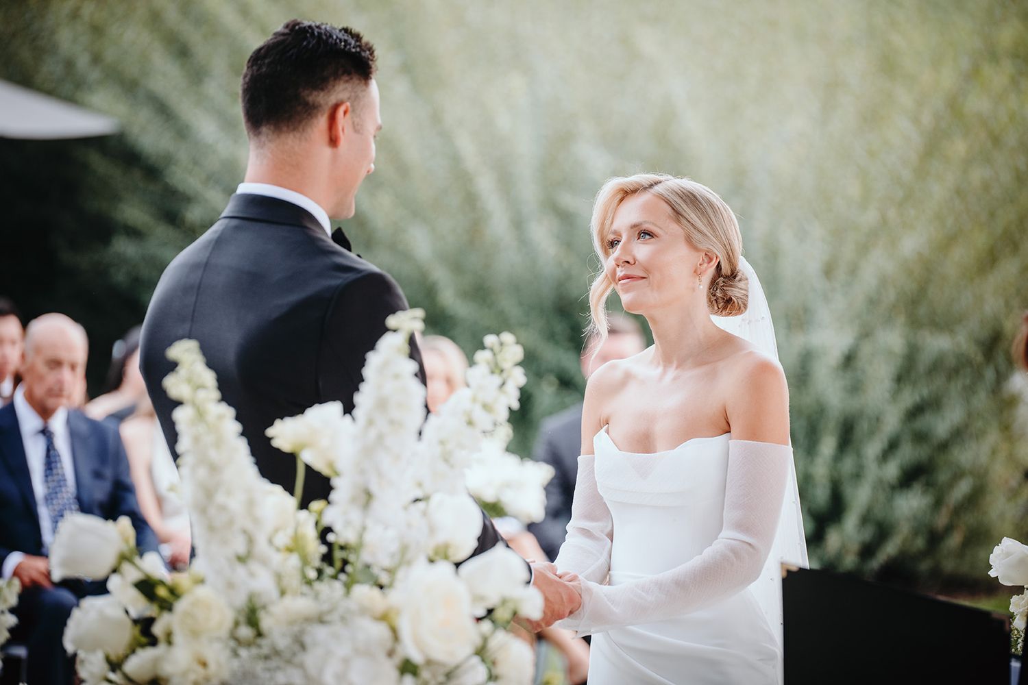 A bride and groom hold hands during their Cedar Creek Winery wedding in Kelowna, BC.